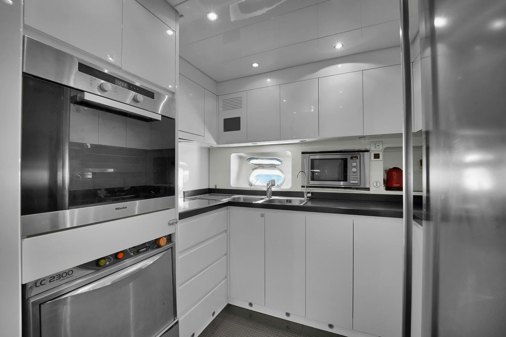a kitchen with white cabinets aboard CHURRI Yacht for Sale