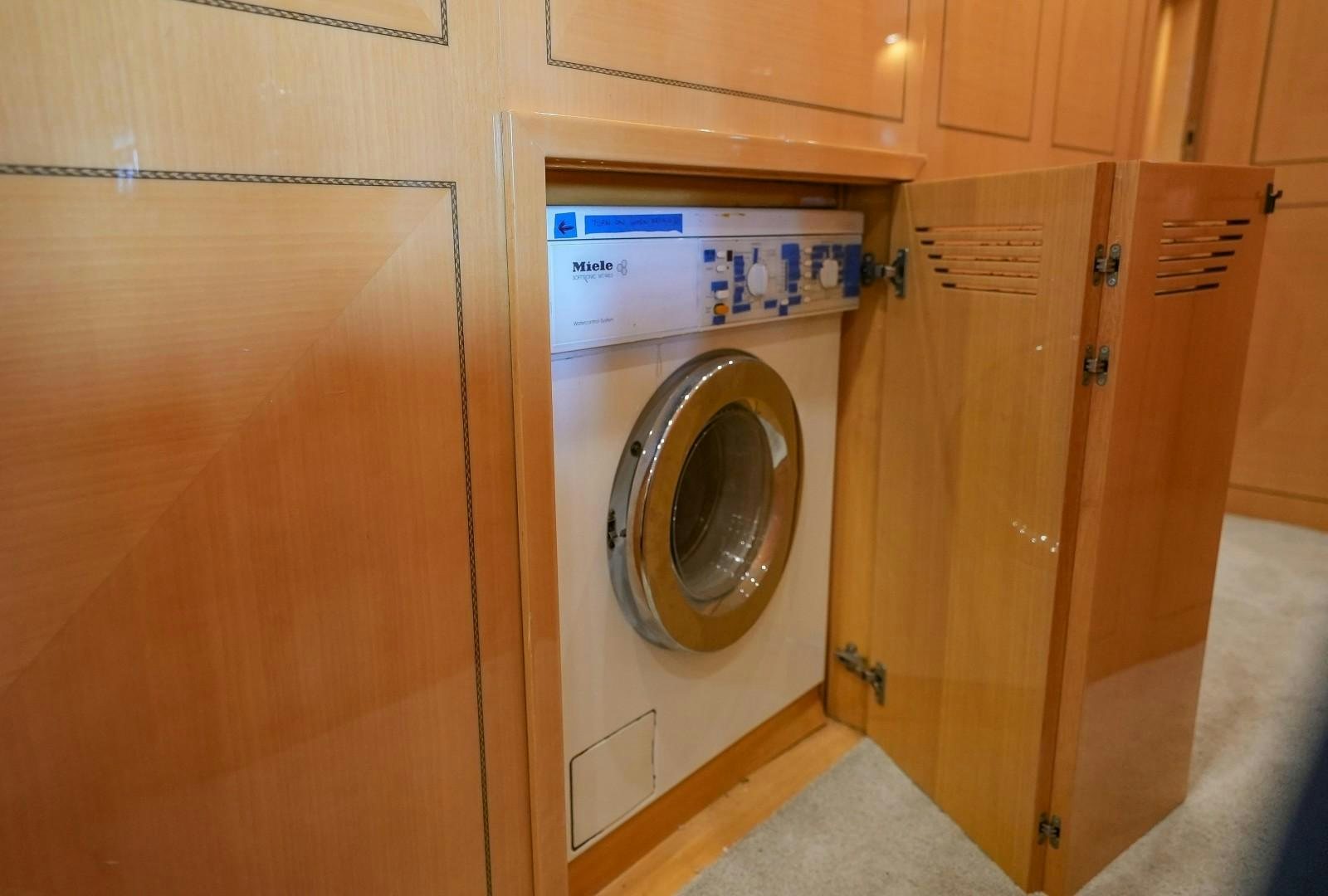 a room with a washing machine and cabinets aboard QUERENCIA Yacht for Sale