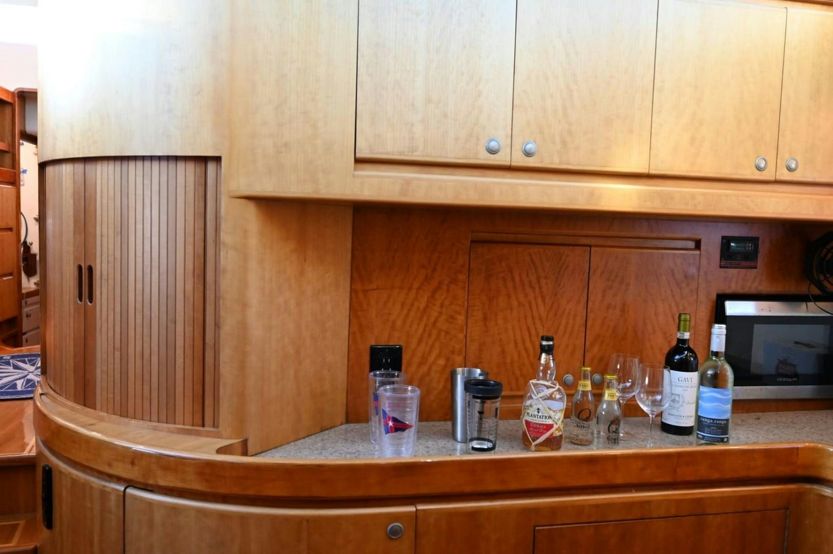 a kitchen counter with bottles and glasses aboard SIRONA Yacht for Sale