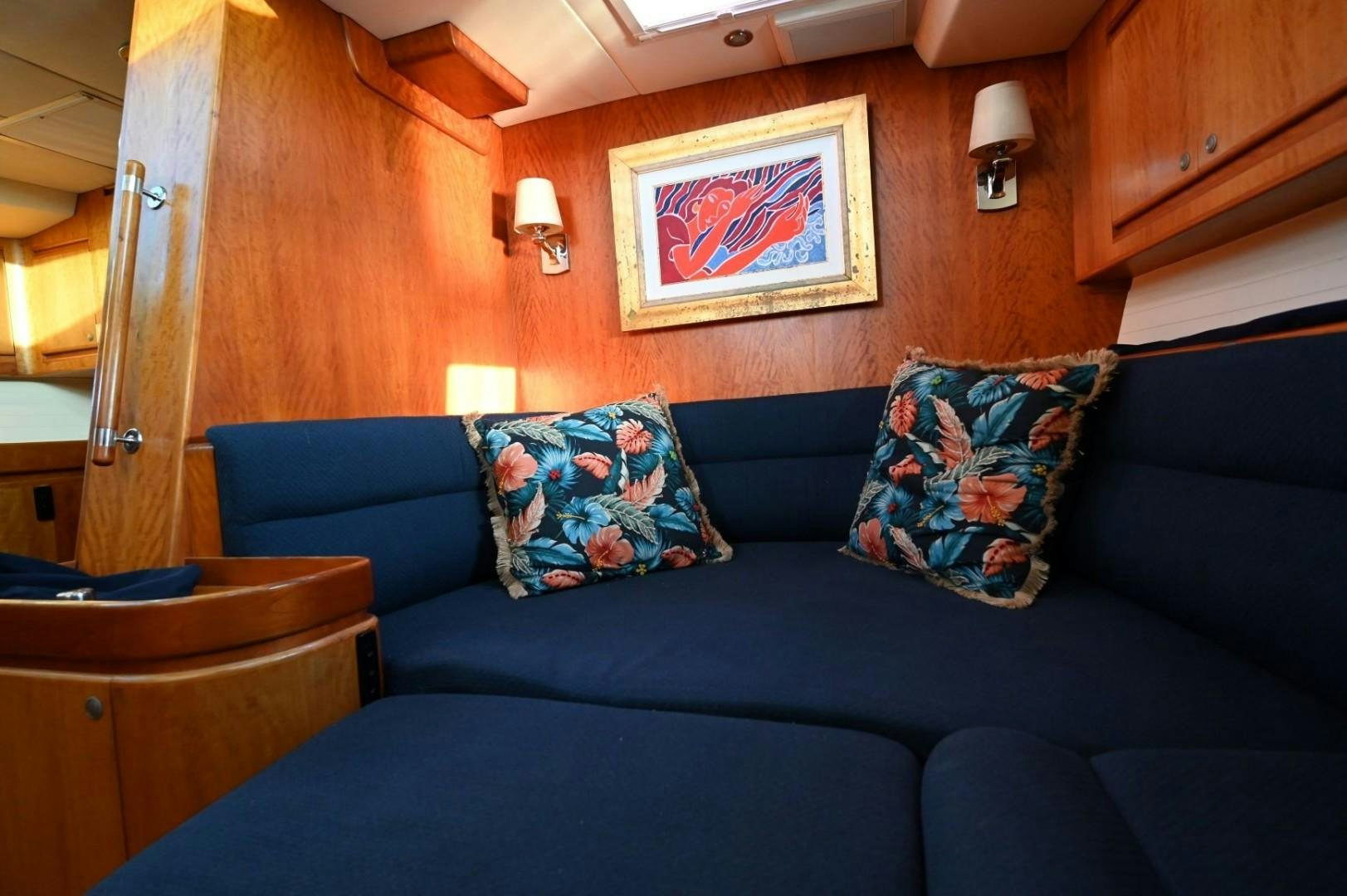a blue couch with a painting on it aboard SIRONA Yacht for Sale