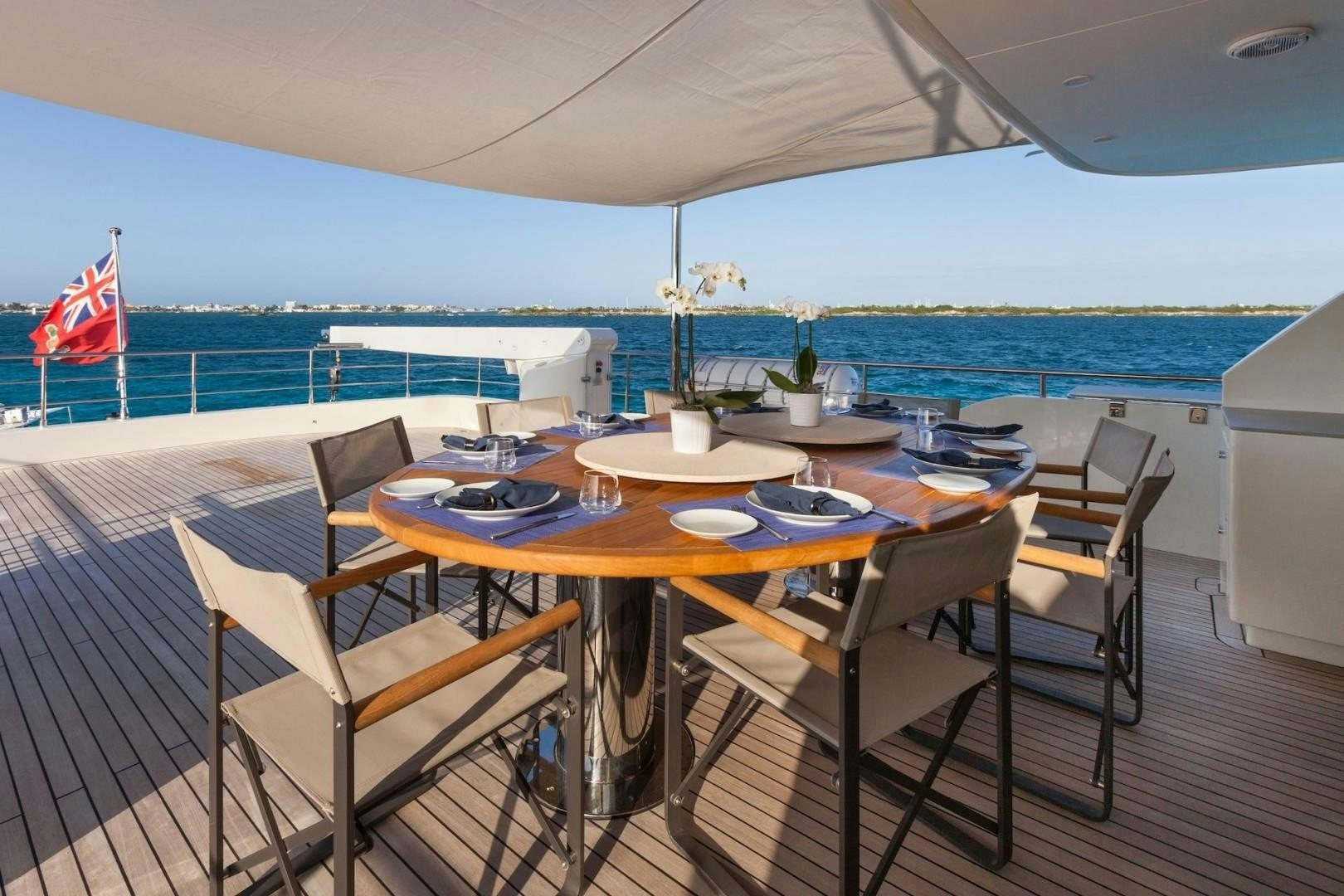 a table set for a meal on a deck overlooking the ocean aboard ACALA Yacht for Sale