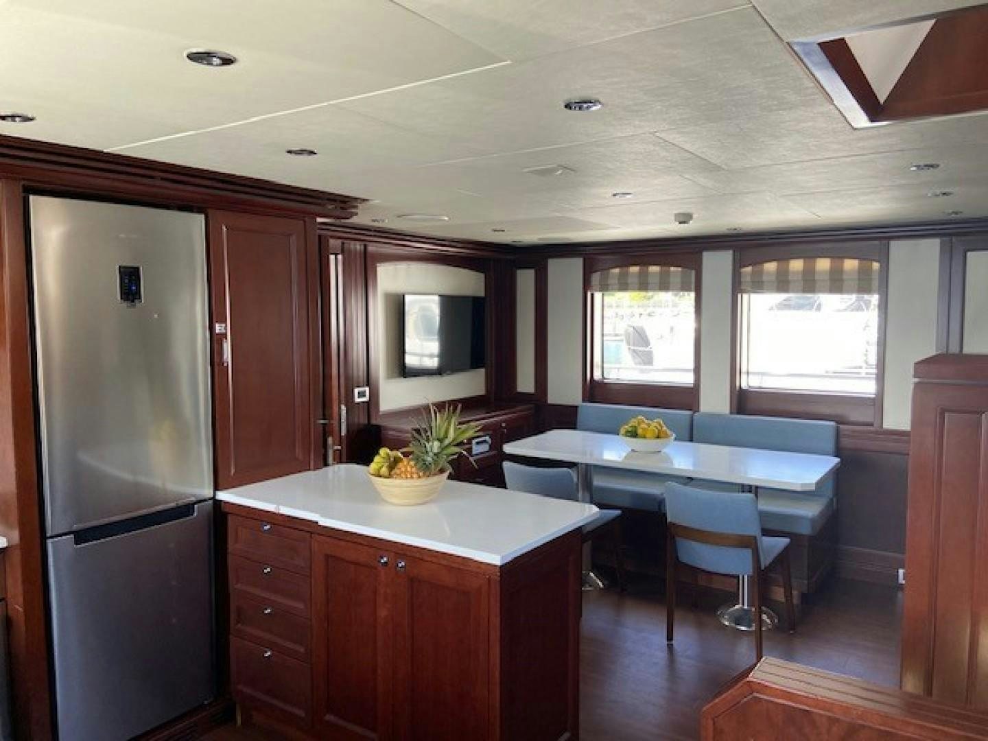 a kitchen with a refrigerator and a table aboard SAMSARA Yacht for Sale