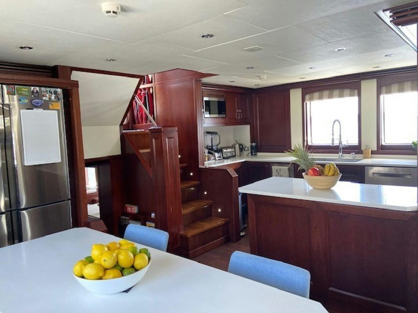 a kitchen with a table and a refrigerator aboard SAMSARA Yacht for Sale