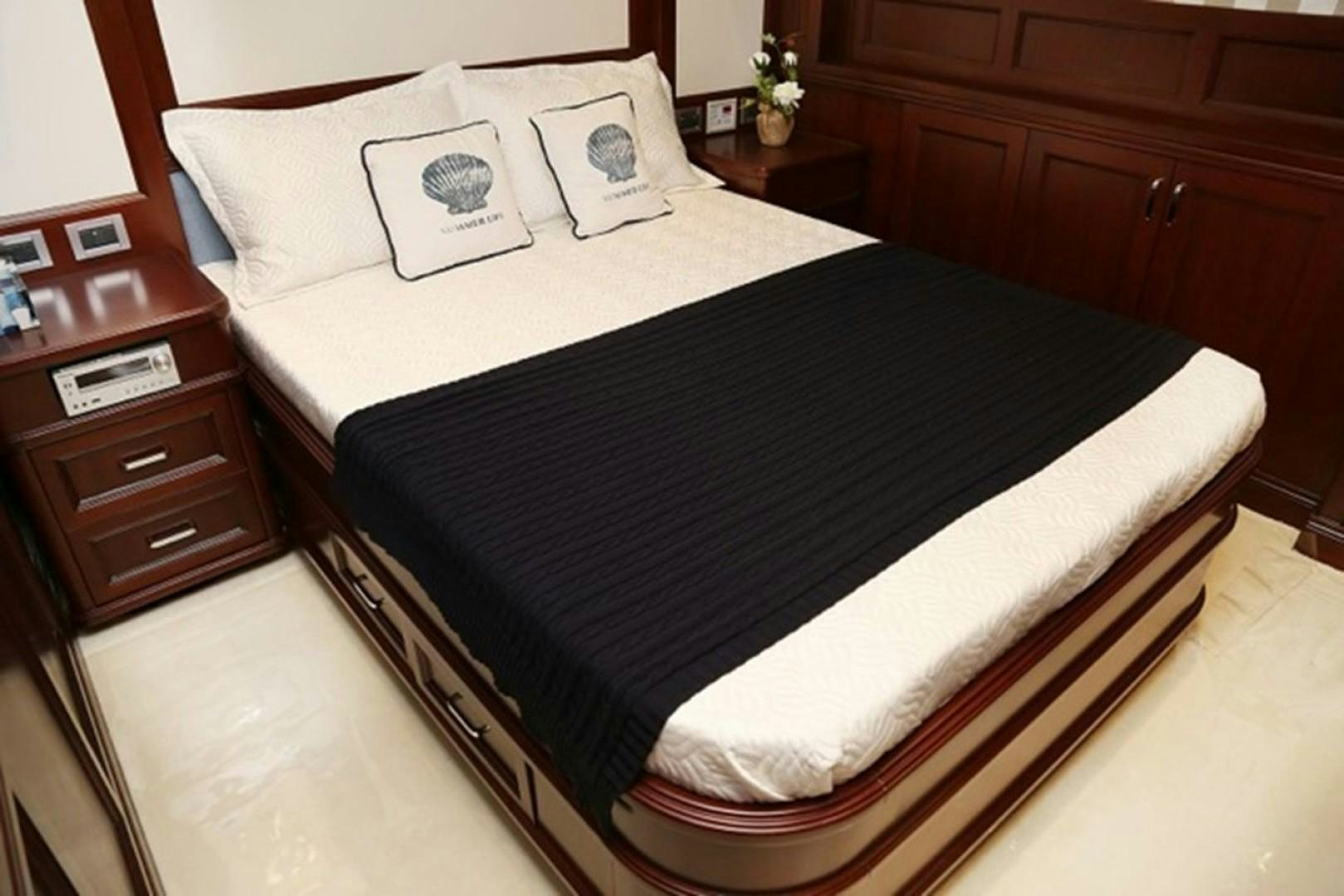 a bed with a black and white comforter and pillows aboard SAMSARA Yacht for Sale