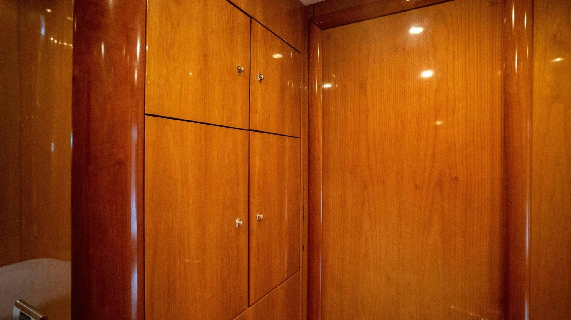 a wooden cabinet with wooden doors aboard LUCKY Yacht for Sale