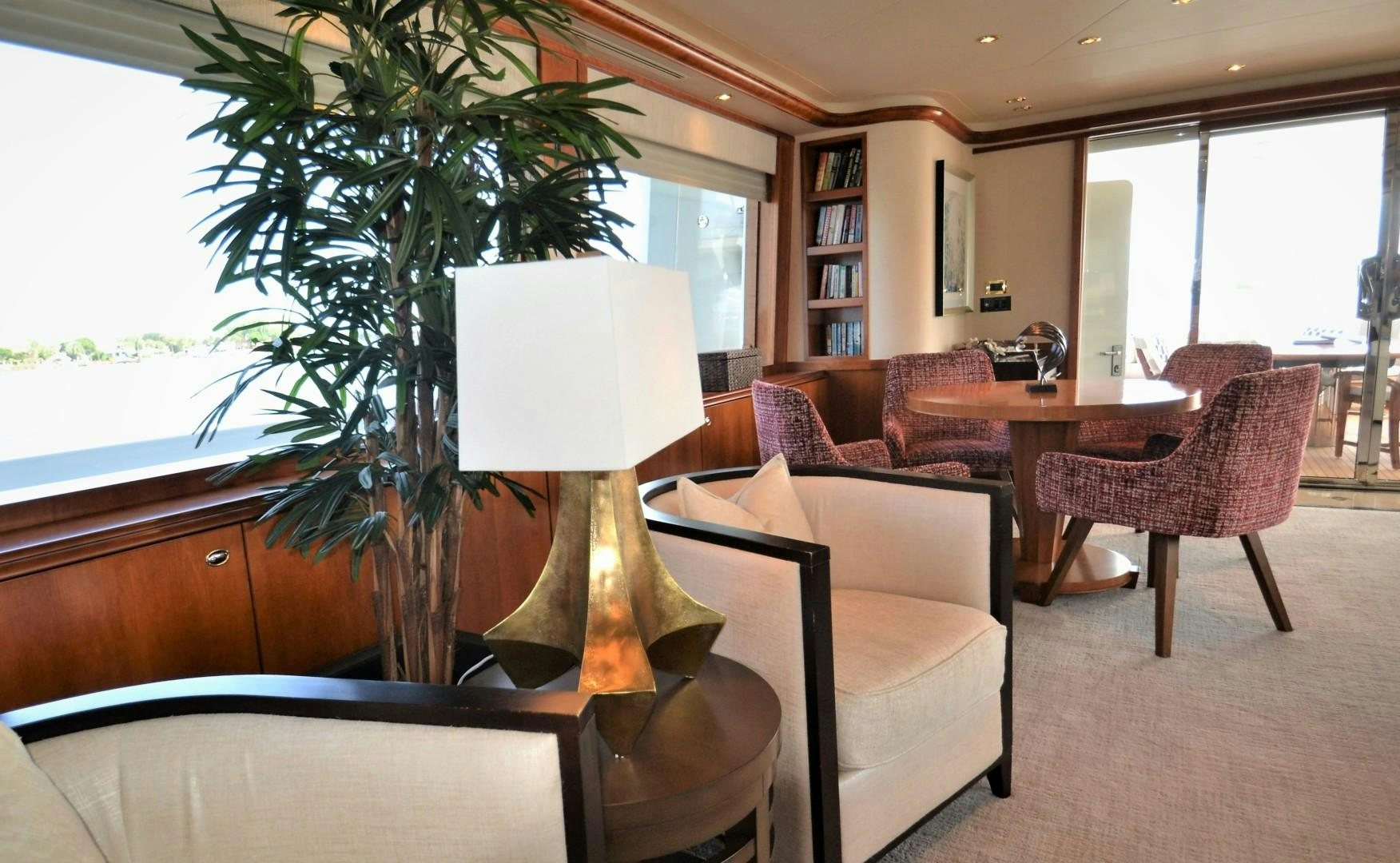 a living room with a lamp and a table with chairs aboard REBELLIOUS Yacht for Sale