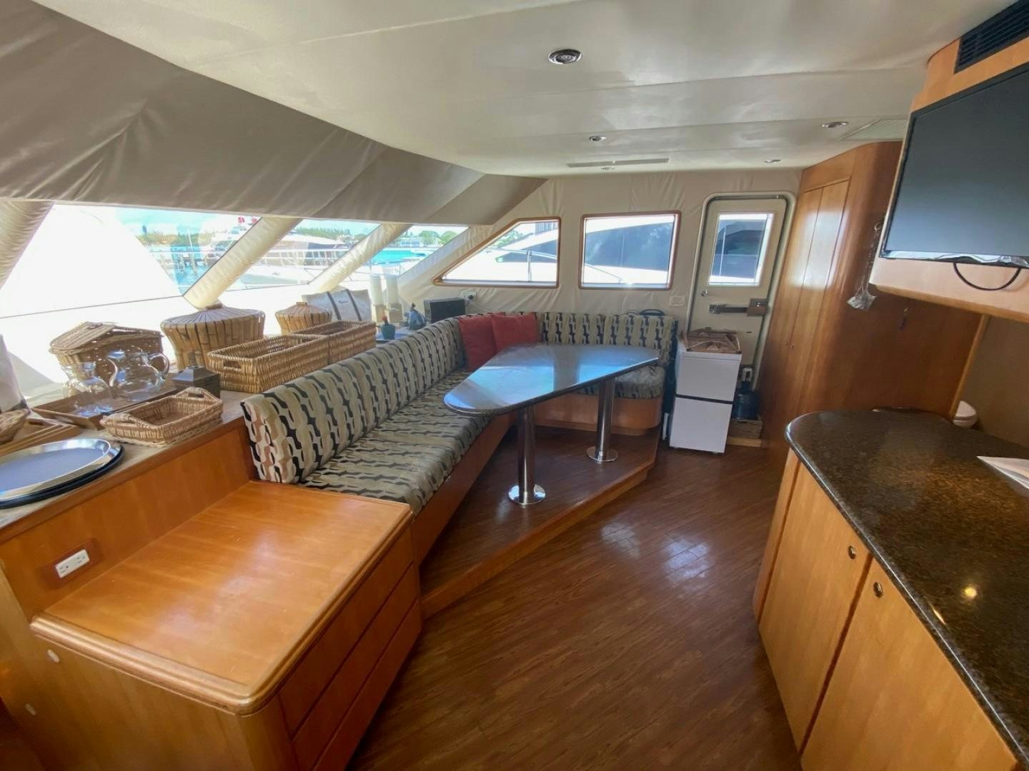 a living room with a couch and a tv aboard EQUINOX X Yacht for Sale