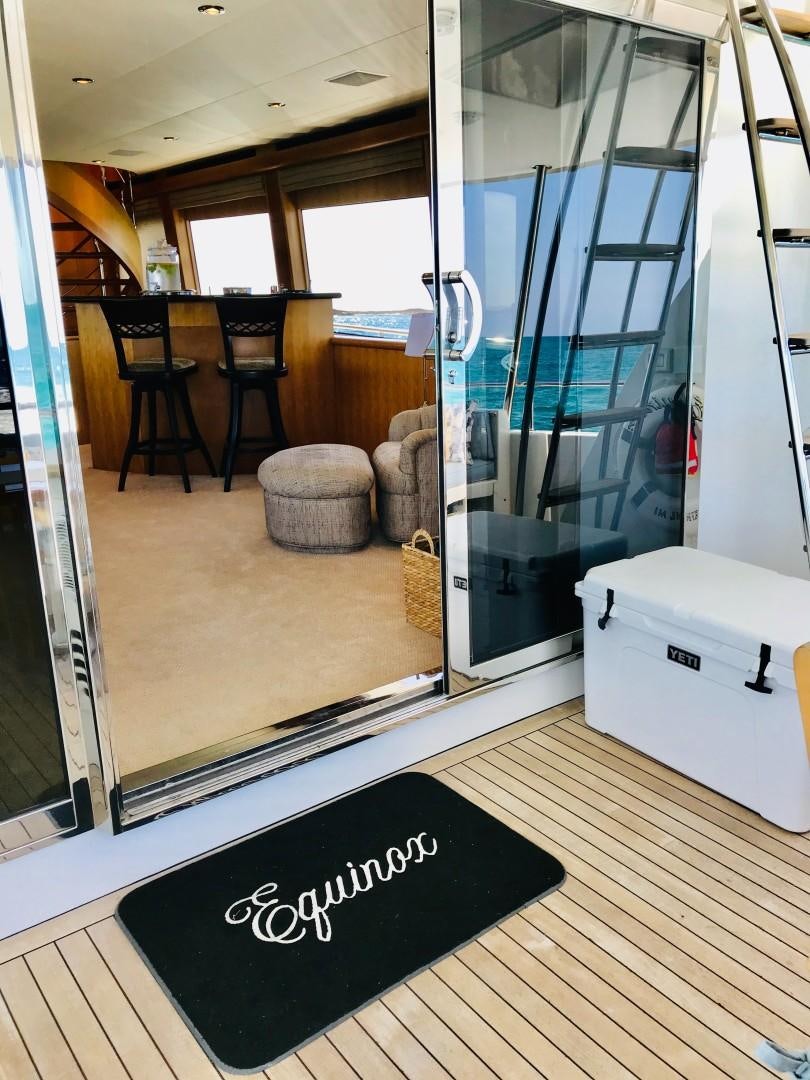 a room with a glass door and a chair and a table aboard EQUINOX X Yacht for Sale