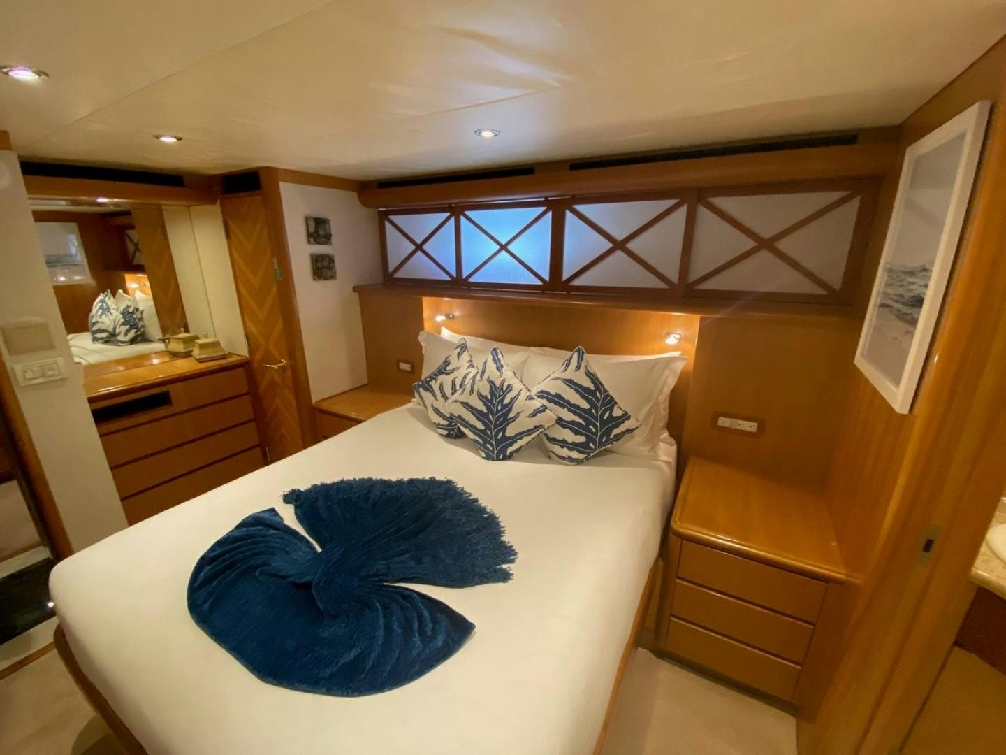 a bed with blue sheets aboard EQUINOX X Yacht for Sale