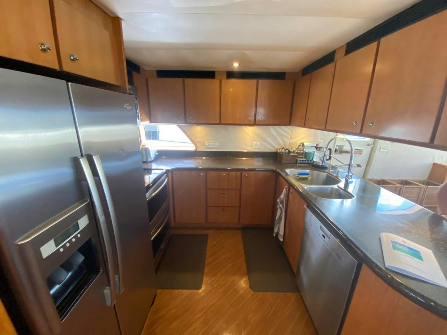 a kitchen with wooden cabinets aboard EQUINOX X Yacht for Sale