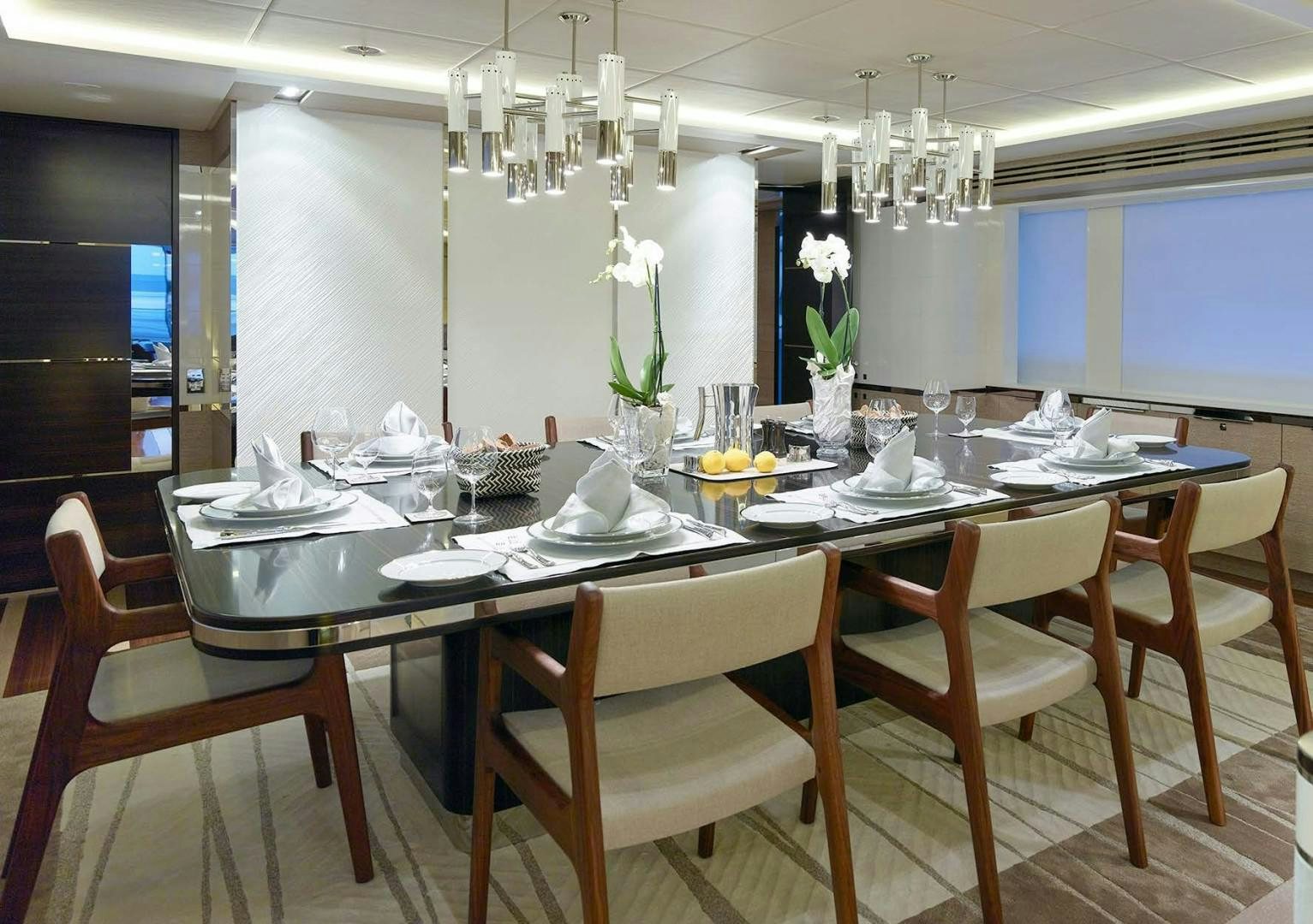 a dining table set with white flowers aboard ASYA Yacht for Sale
