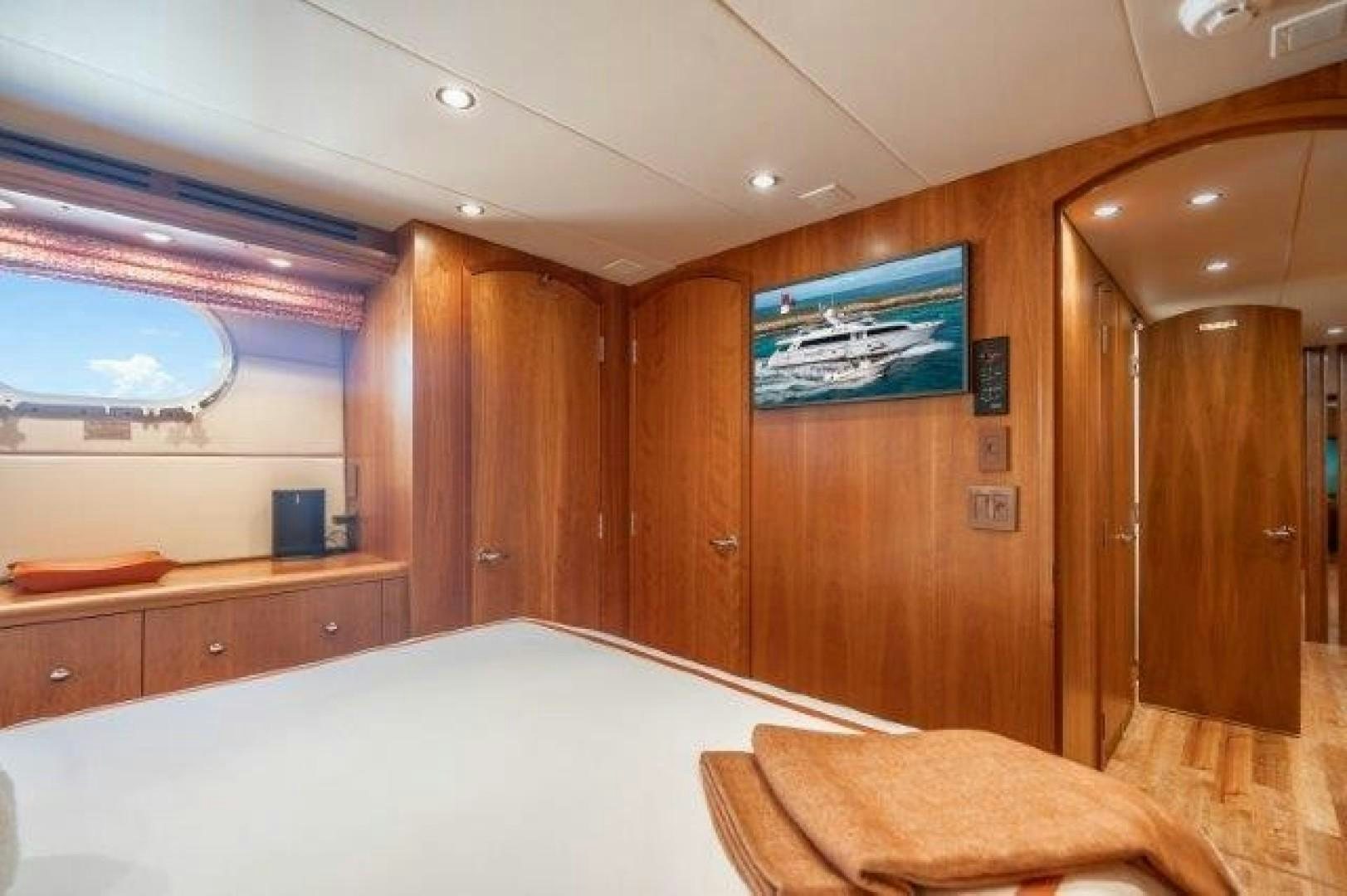 a room with a bed and a wood cabinet aboard CENTODUE Yacht for Sale