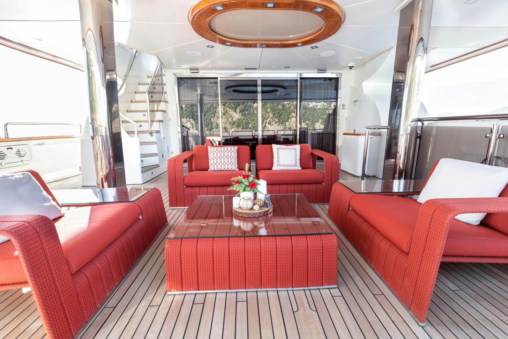 a room with red seats and tables aboard PANAKEIA Yacht for Charter