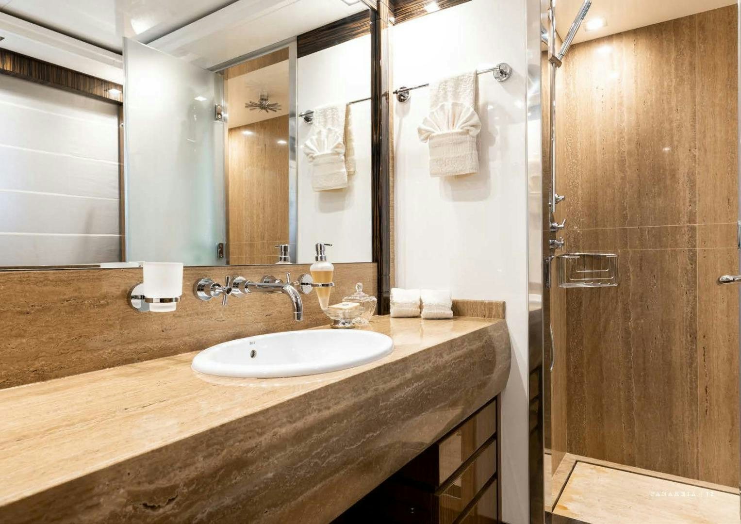 a bathroom with a countertop sink and a mirror aboard PANAKEIA Yacht for Charter