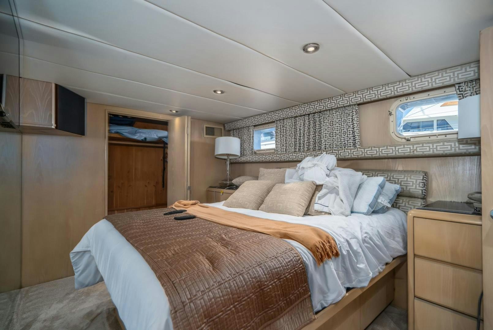 a bedroom with a bed and a television on the wall aboard SOVEREIGN LADY Yacht for Sale