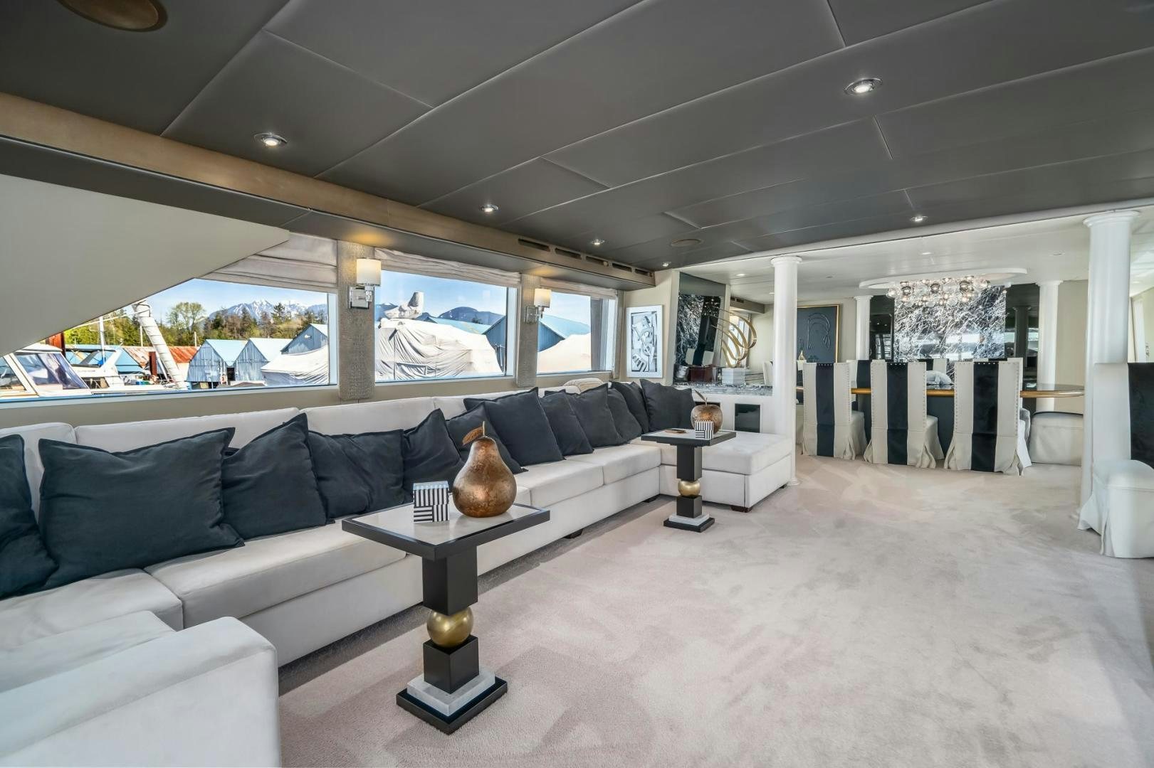 a living room with a large white sofa and a large window aboard SOVEREIGN LADY Yacht for Sale
