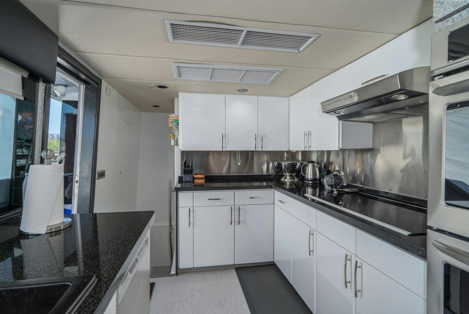 a kitchen with white cabinets aboard SOVEREIGN LADY Yacht for Sale