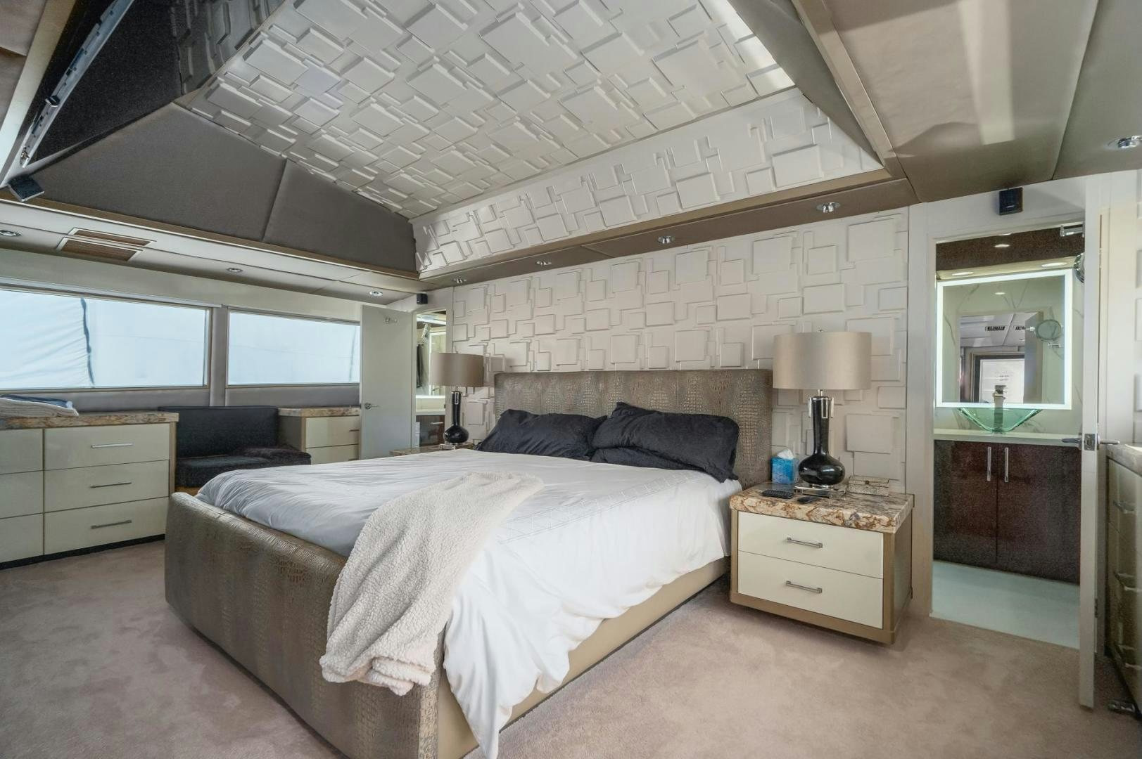 a bedroom with a bed and a dresser aboard SOVEREIGN LADY Yacht for Sale