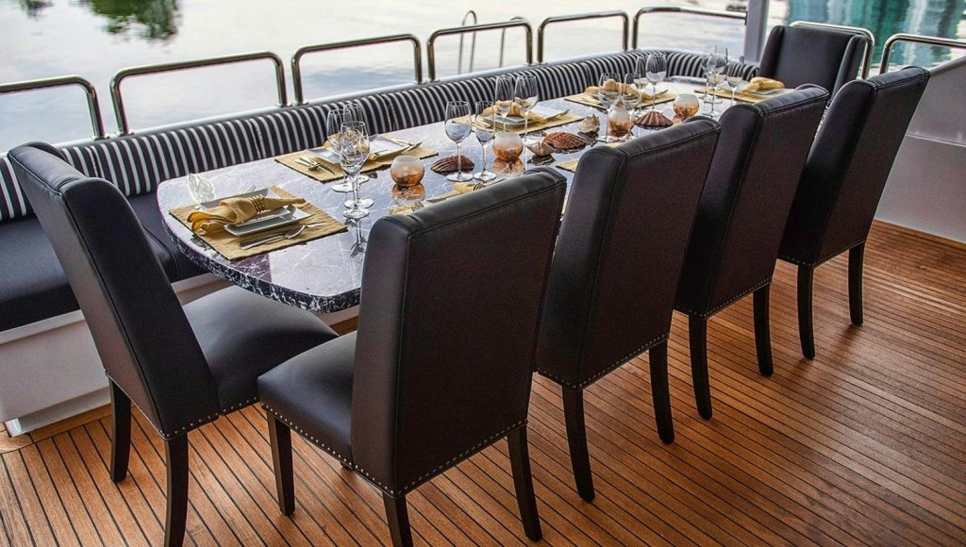 a table with chairs and a set of plates on it aboard SOVEREIGN LADY Yacht for Sale