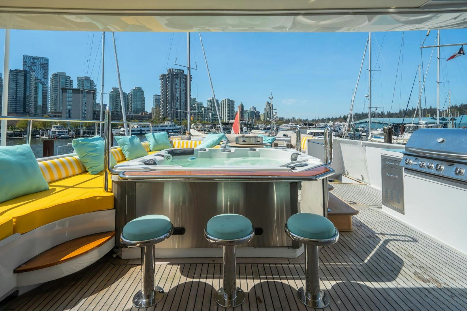 a table with stools on it next to a boat aboard SOVEREIGN LADY Yacht for Sale