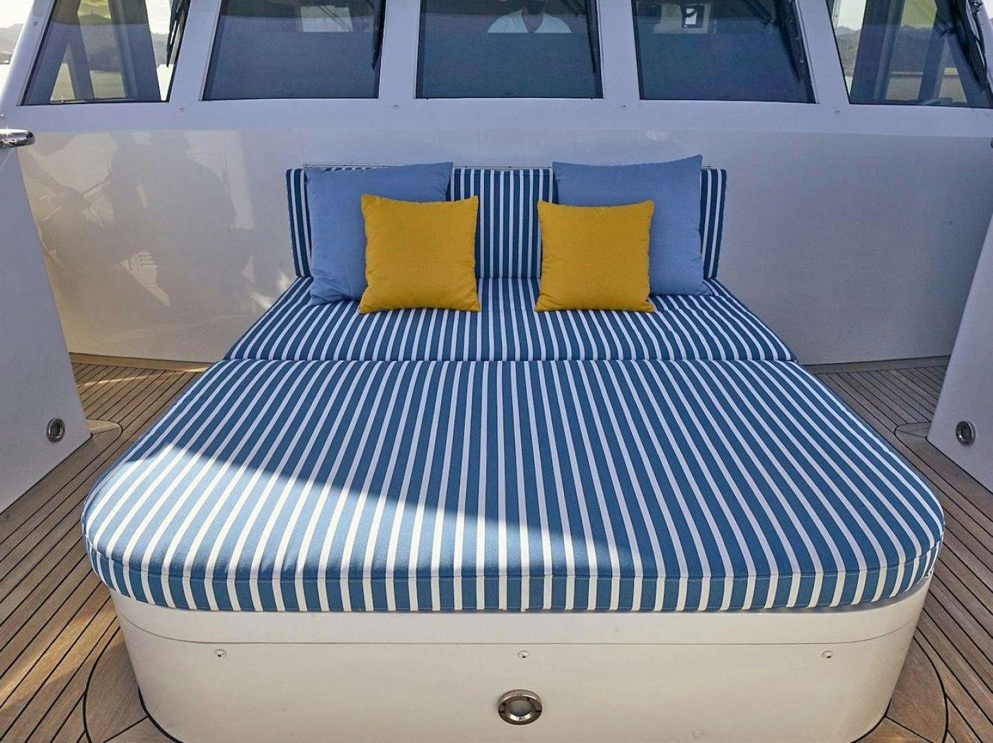 a bed with blue and white striped sheets aboard ALAIA Yacht for Sale