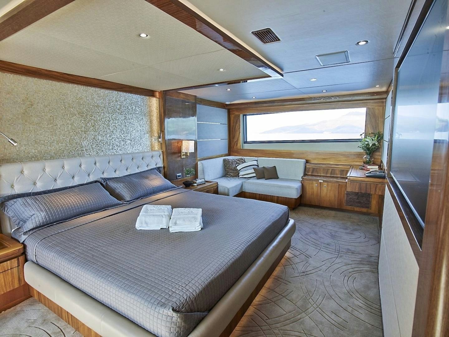 a large bedroom with a bed and a couch aboard ALAIA Yacht for Sale