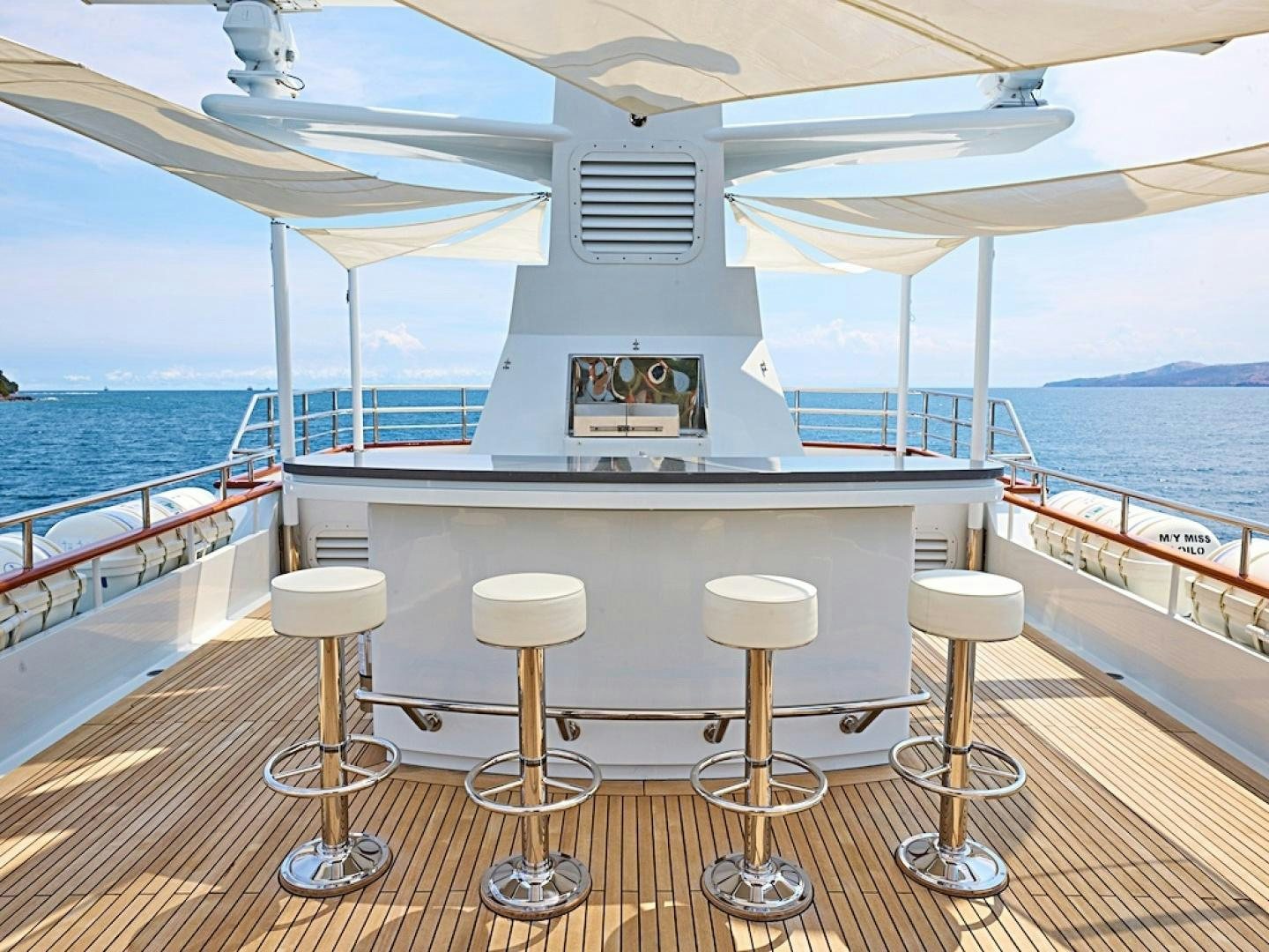 a boat with stools on a deck aboard ALAIA Yacht for Sale