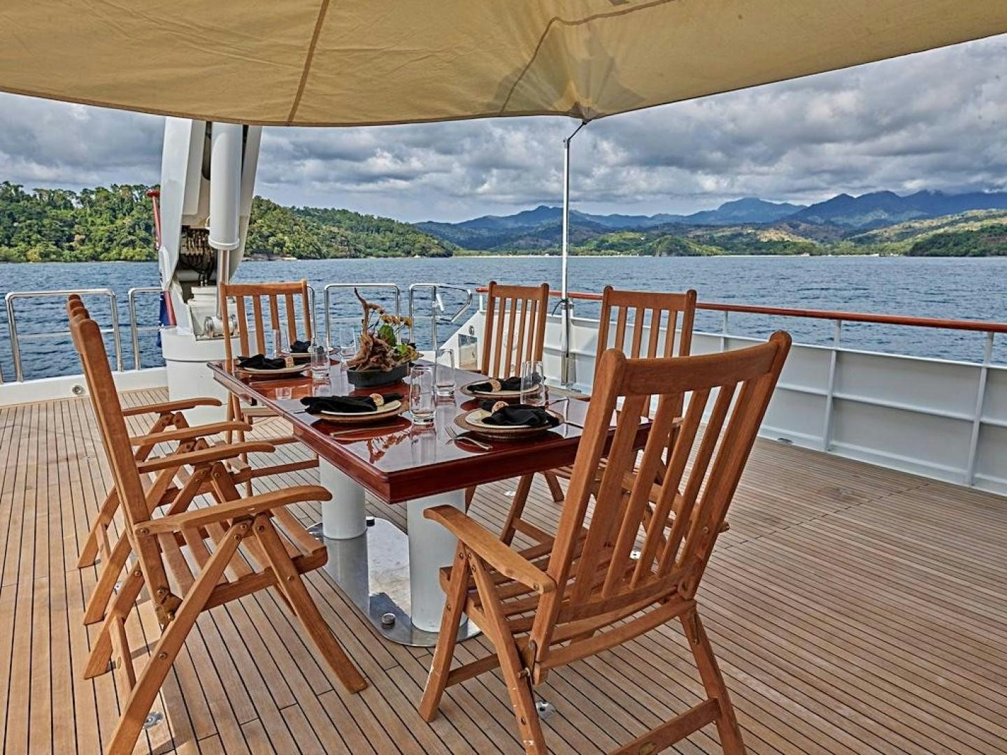 a table set for dinner on a deck overlooking a body of water aboard ALAIA Yacht for Sale