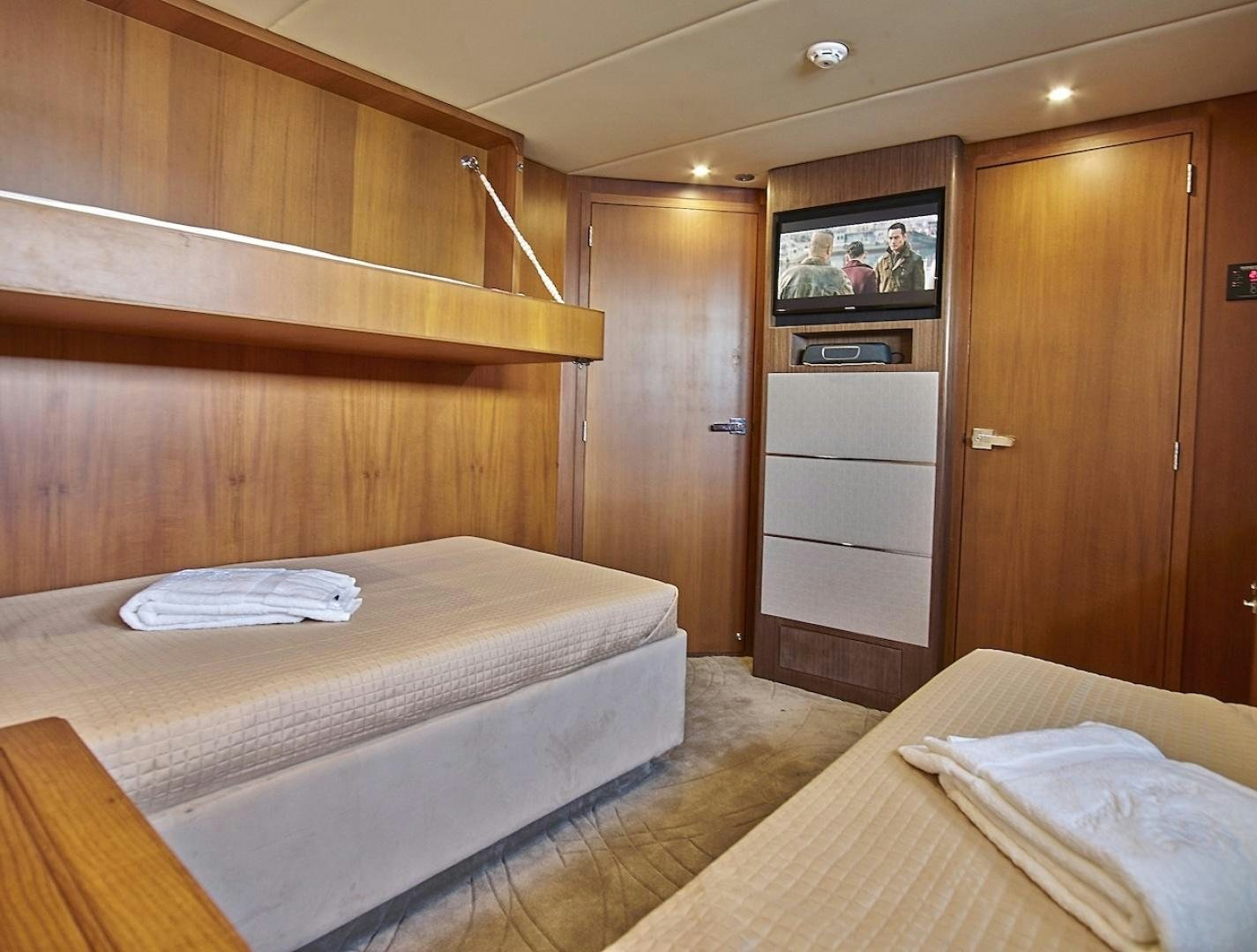 a bedroom with a bed and a television aboard ALAIA Yacht for Sale