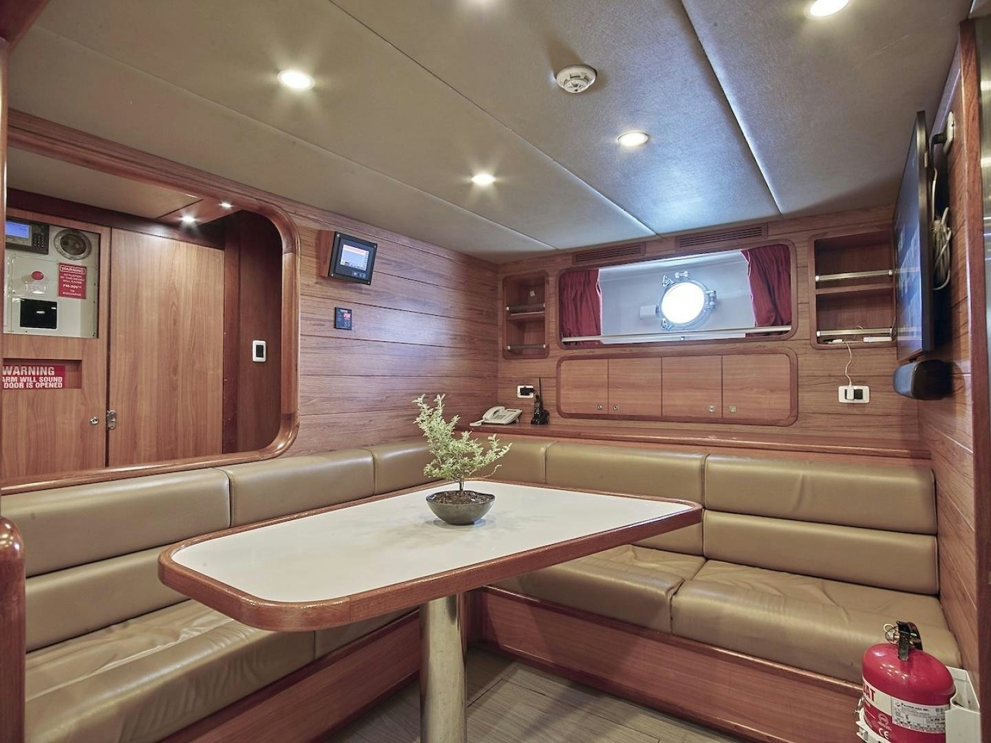 a room with a table and couch aboard ALAIA Yacht for Sale