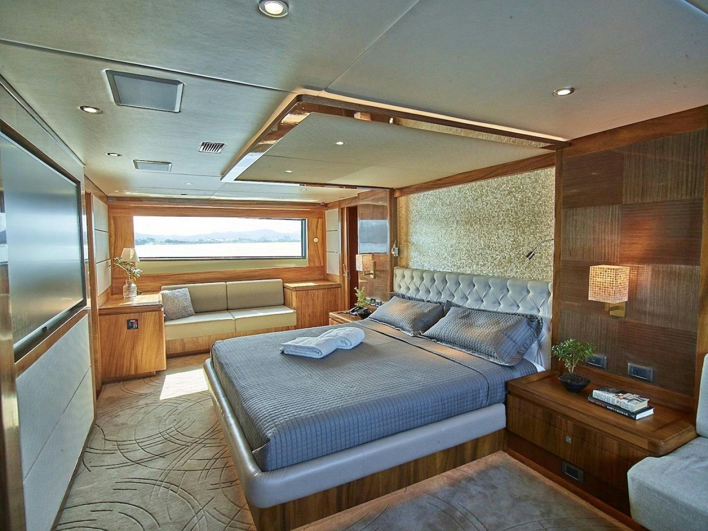 a bedroom with a bed and a couch aboard ALAIA Yacht for Sale