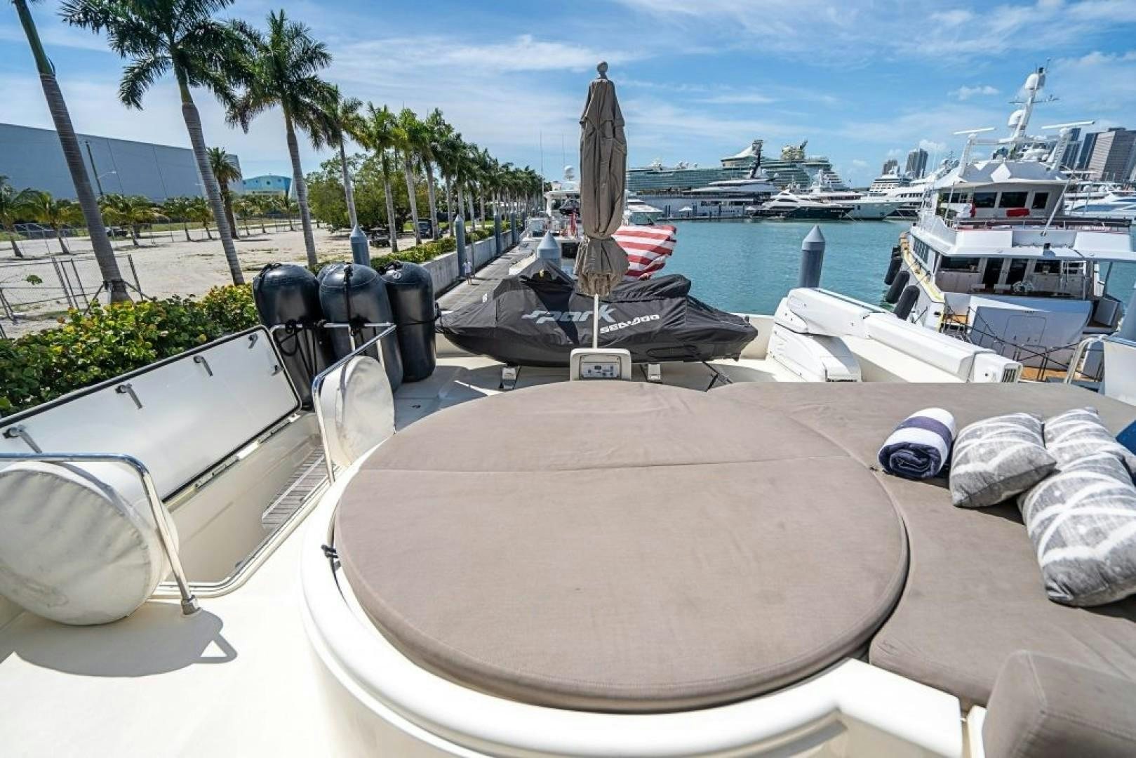a table with chairs and a boat in the water aboard CINQUE MARE Yacht for Sale