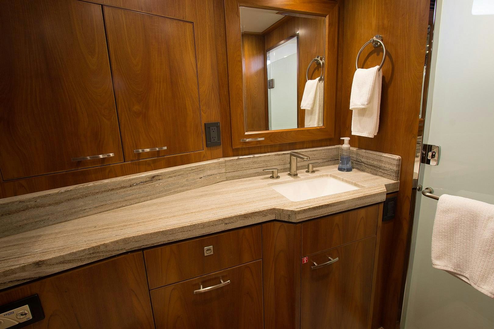 a bathroom with a countertop sink and mirror aboard LET IT BEE Yacht for Sale