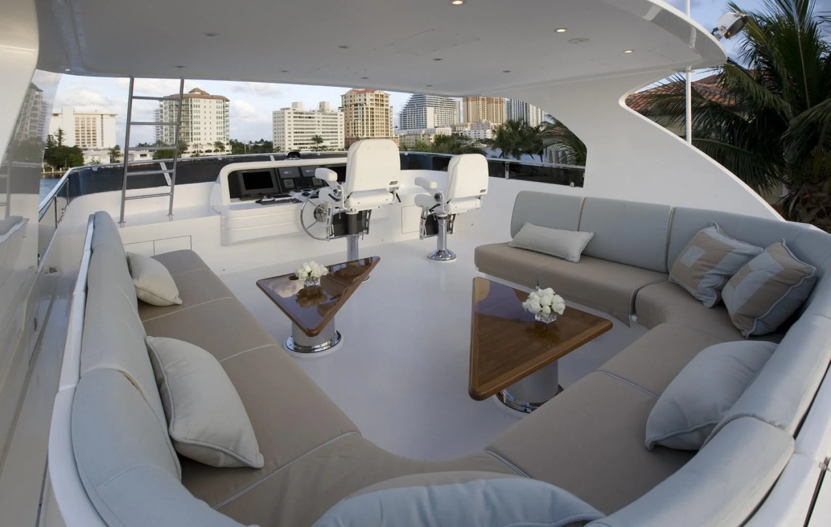 a large white lounge chair in a room with a large white sofa and a table with chairs and aboard SANDRINE Yacht for Sale