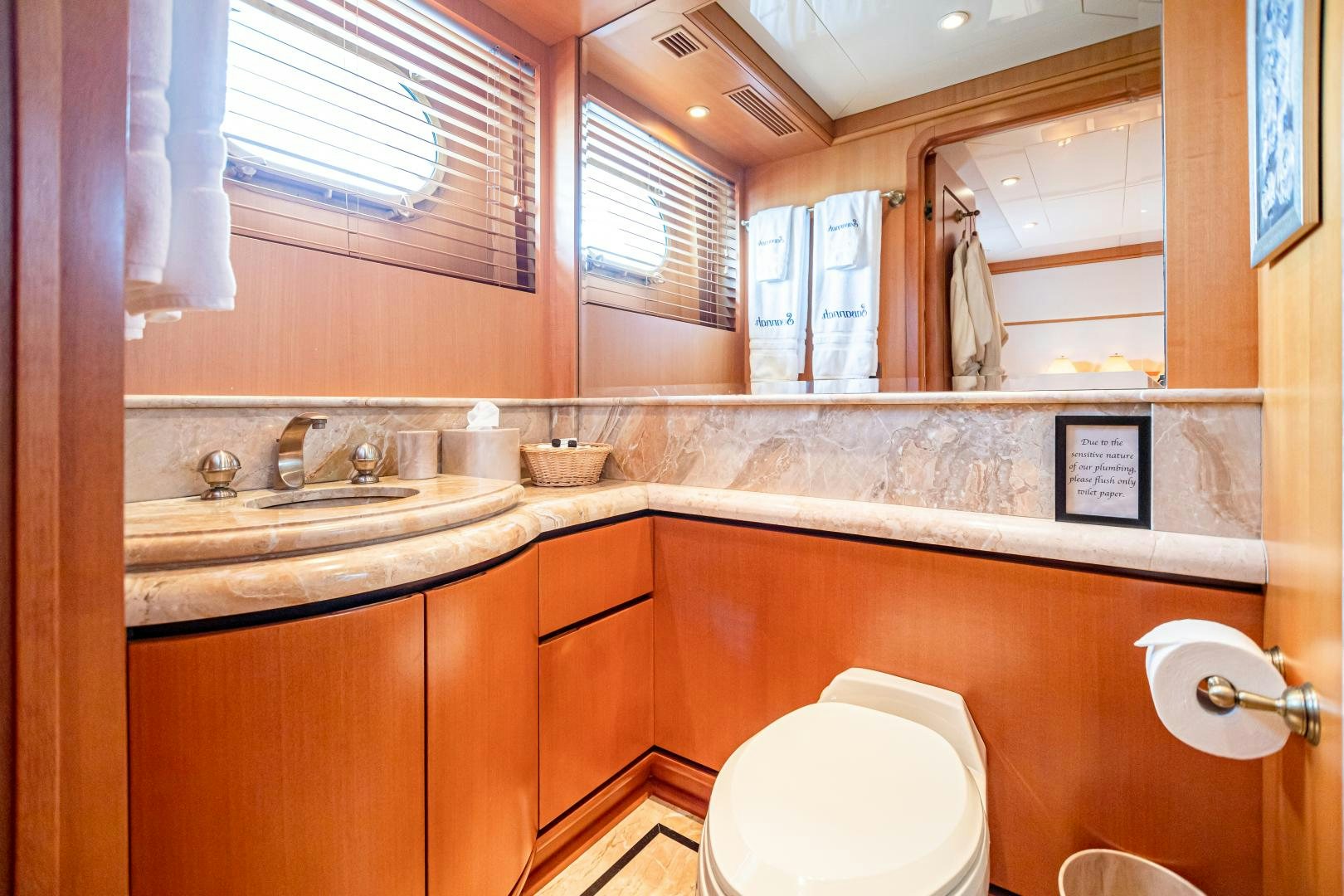 a bathroom with a sink toilet and a mirror aboard XOXO Yacht for Sale