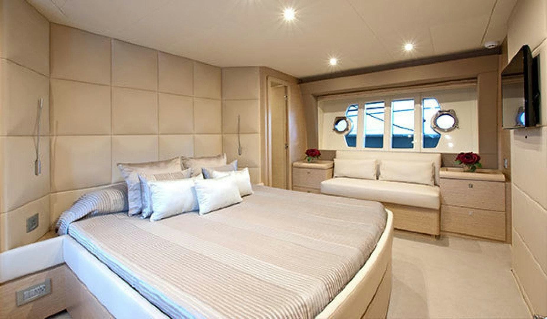 a bedroom with a bed and a couch aboard BLUE ABALONE Yacht for Sale