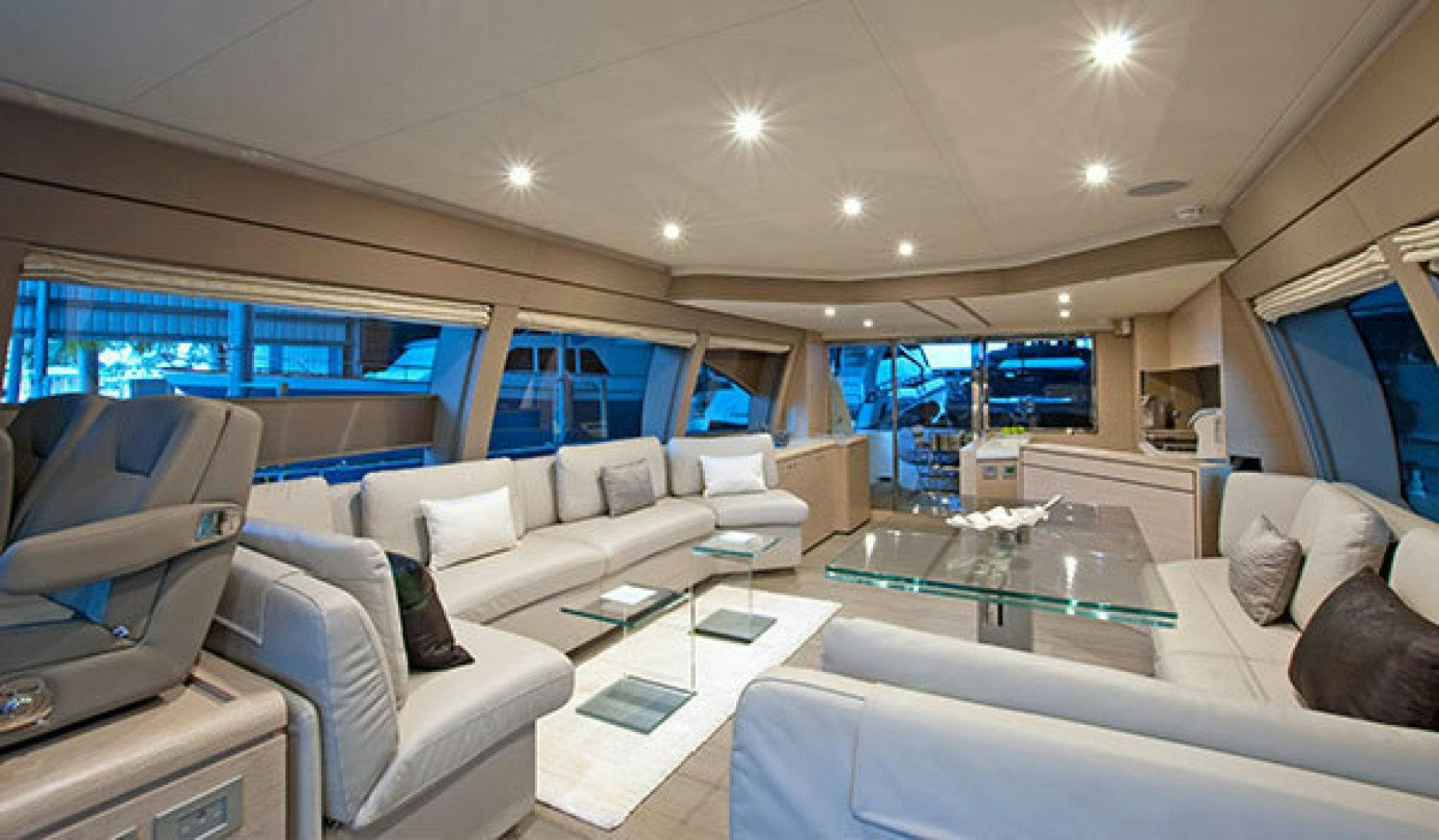 a living room with a large glass table and a large window aboard BLUE ABALONE Yacht for Sale