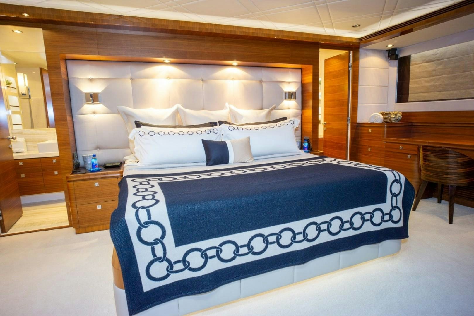 a bed with a blue and white bed spread aboard IN THE ZONE Yacht for Sale