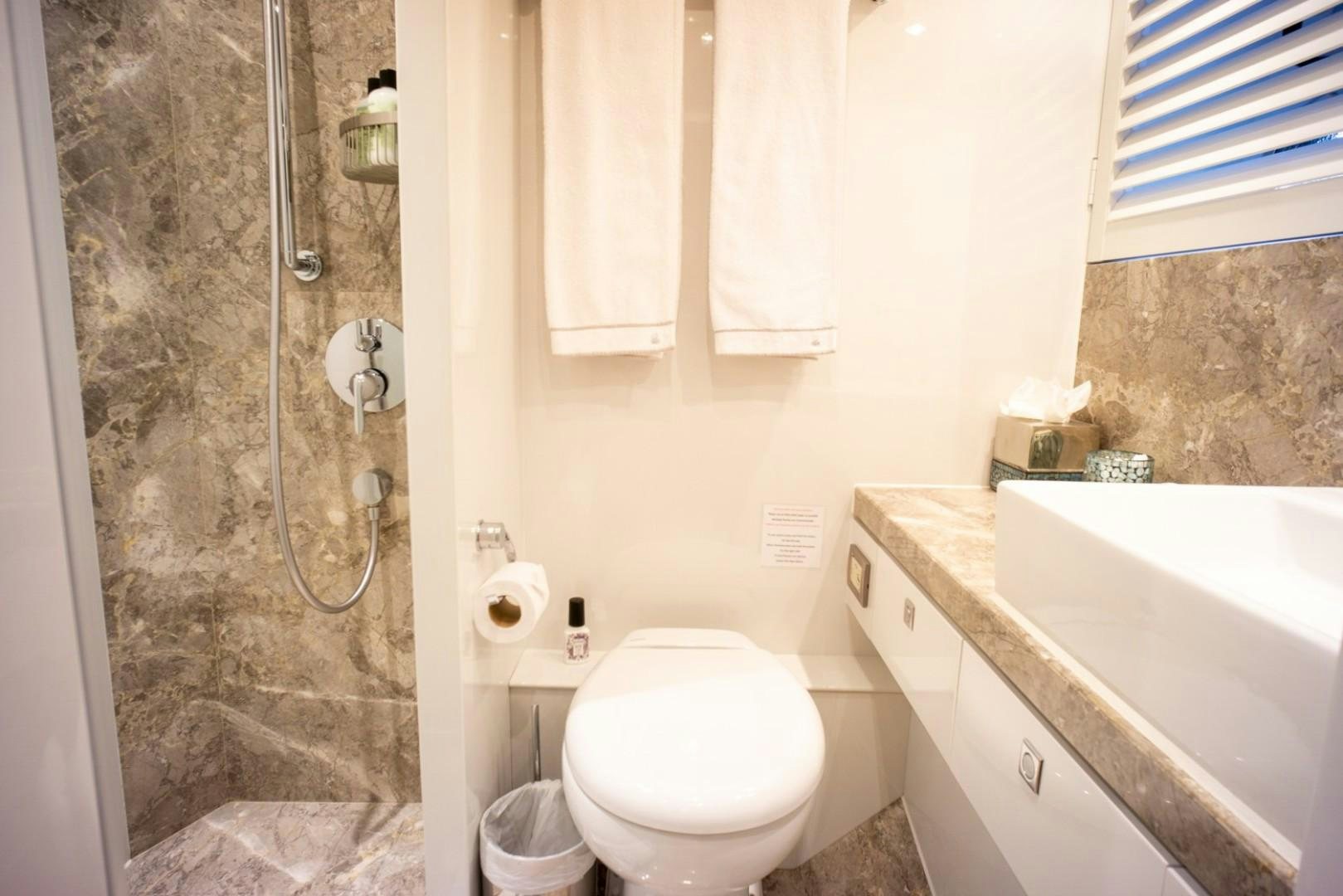 a bathroom with a toilet and sink aboard IN THE ZONE Yacht for Sale