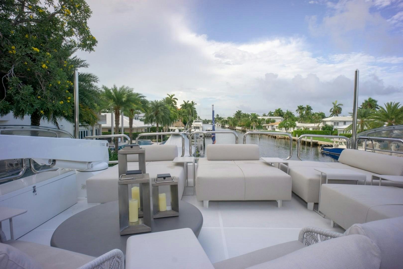 a large white lounge chair on a deck with a pool and trees aboard IN THE ZONE Yacht for Sale