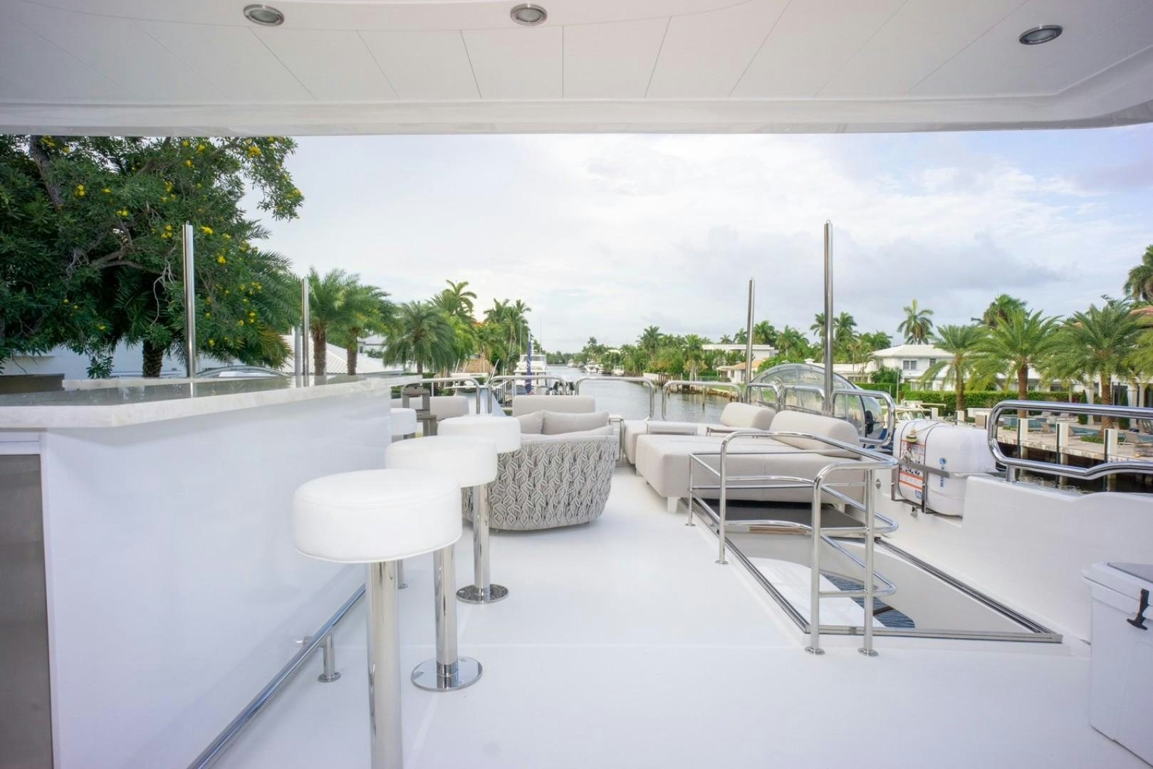 a white lounge area with tables and chairs aboard IN THE ZONE Yacht for Sale