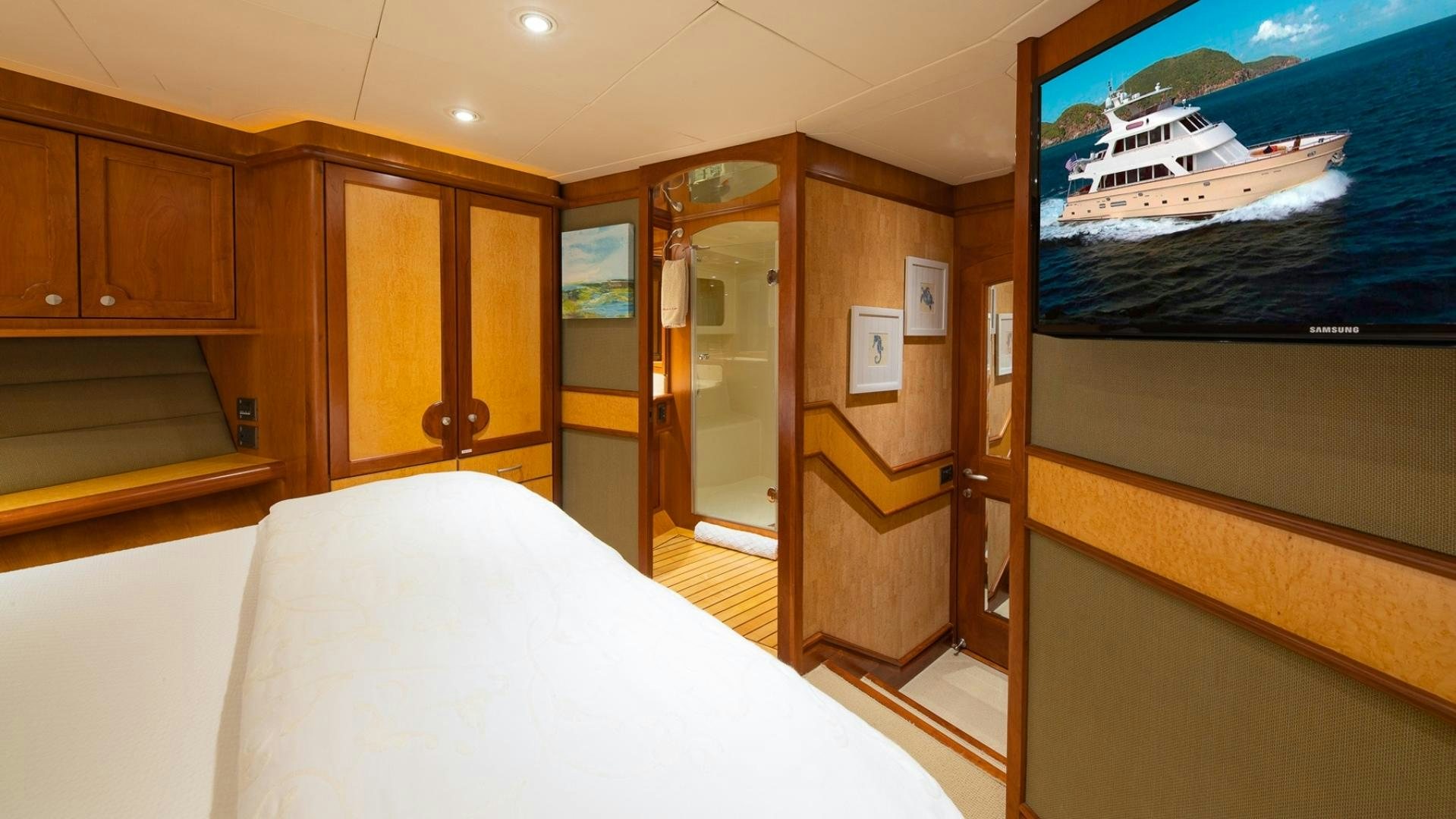 a room with a bed and a television aboard MAGICAL DAYS Yacht for Sale