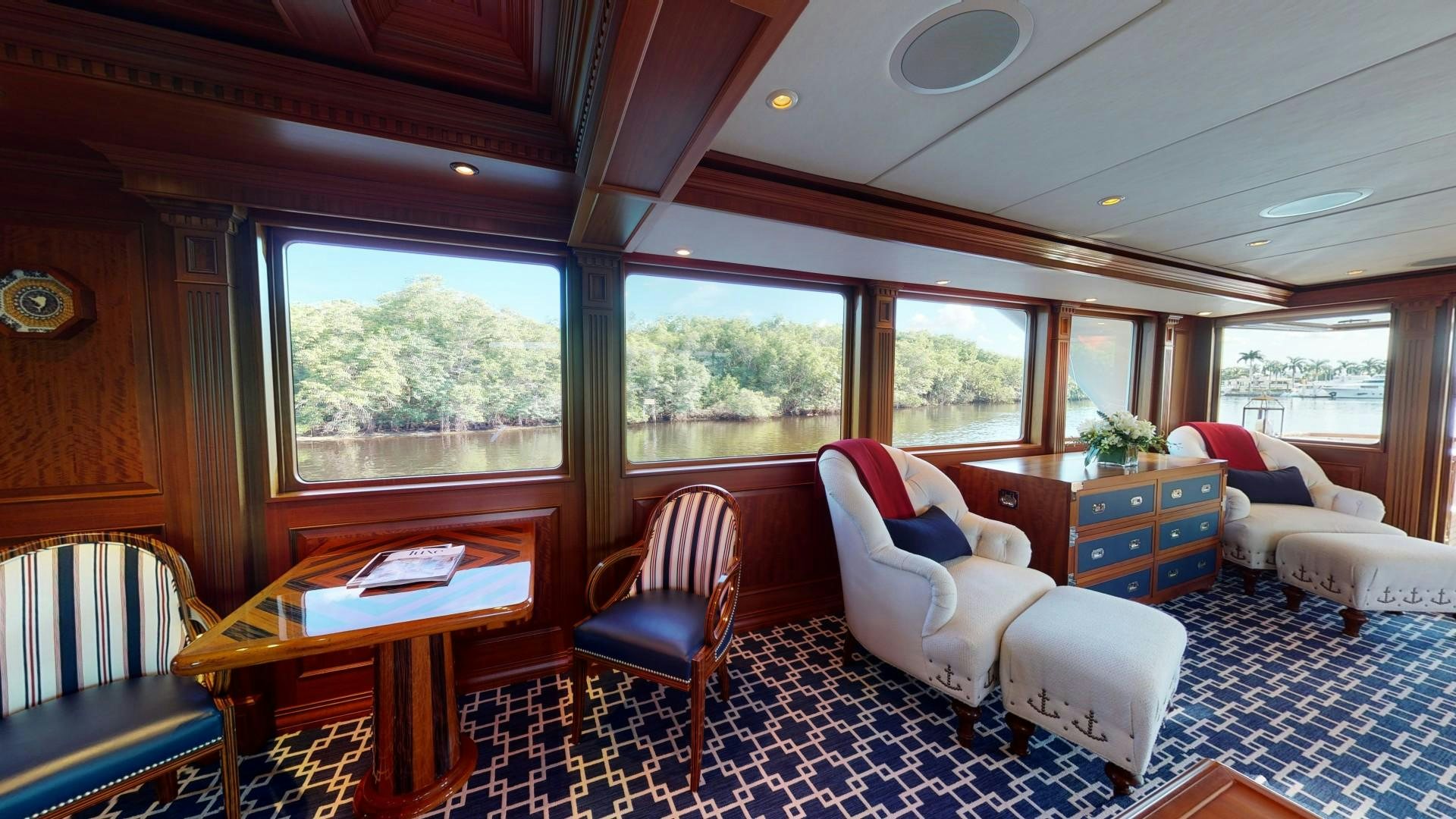a living room with a table and chairs aboard PATRIOT Yacht for Sale