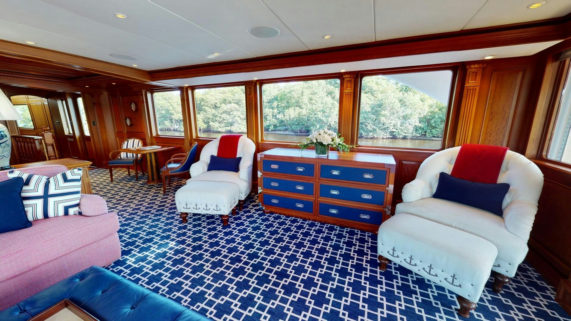 a large bedroom with a blue and white rug aboard PATRIOT Yacht for Sale
