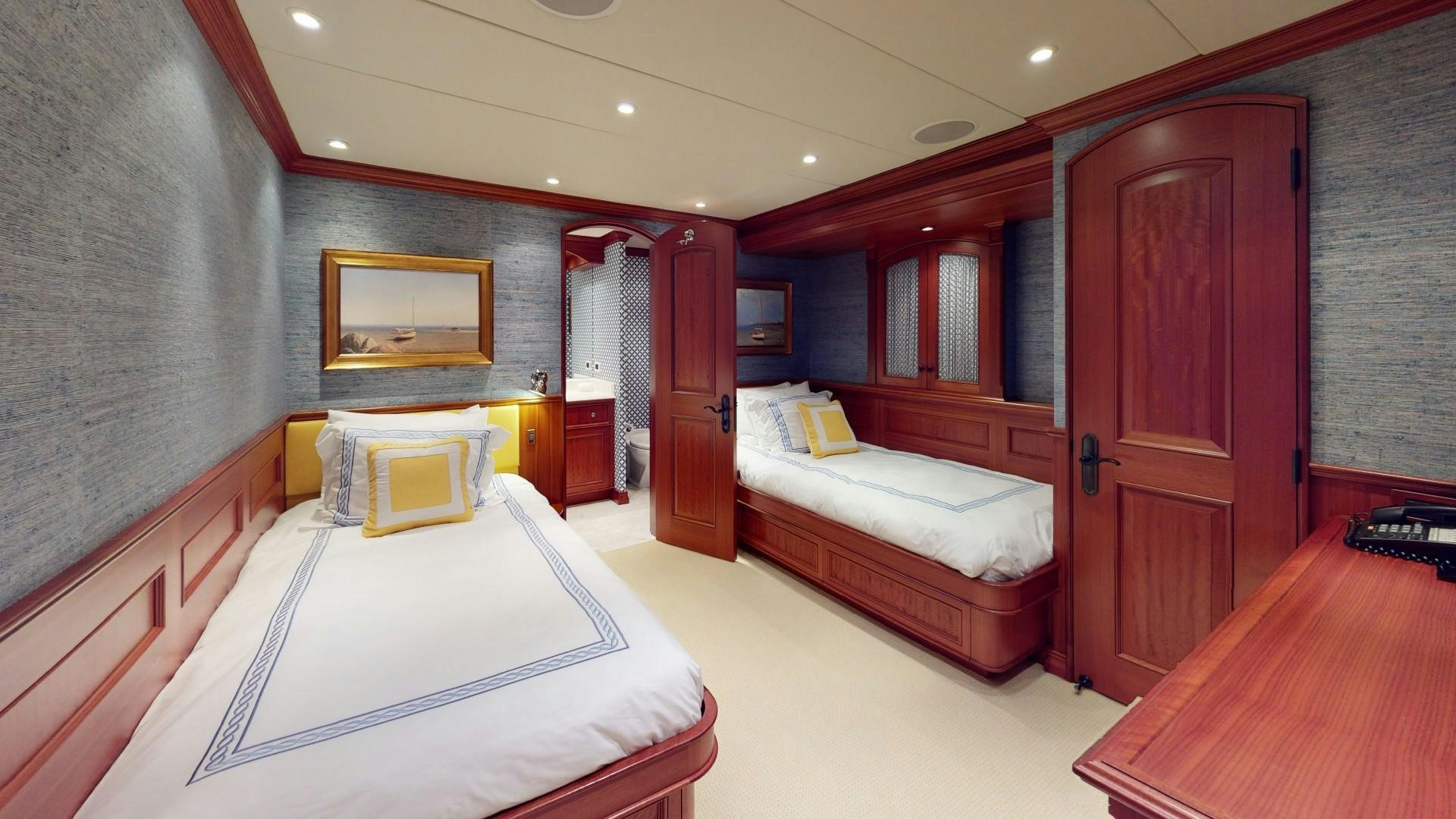 a room with a bed and a desk aboard PATRIOT Yacht for Sale