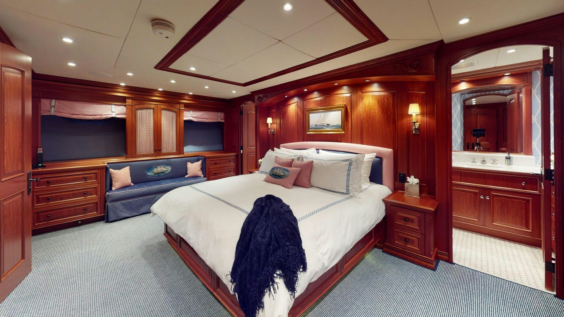 a bedroom with a bed and a mirror aboard PATRIOT Yacht for Sale