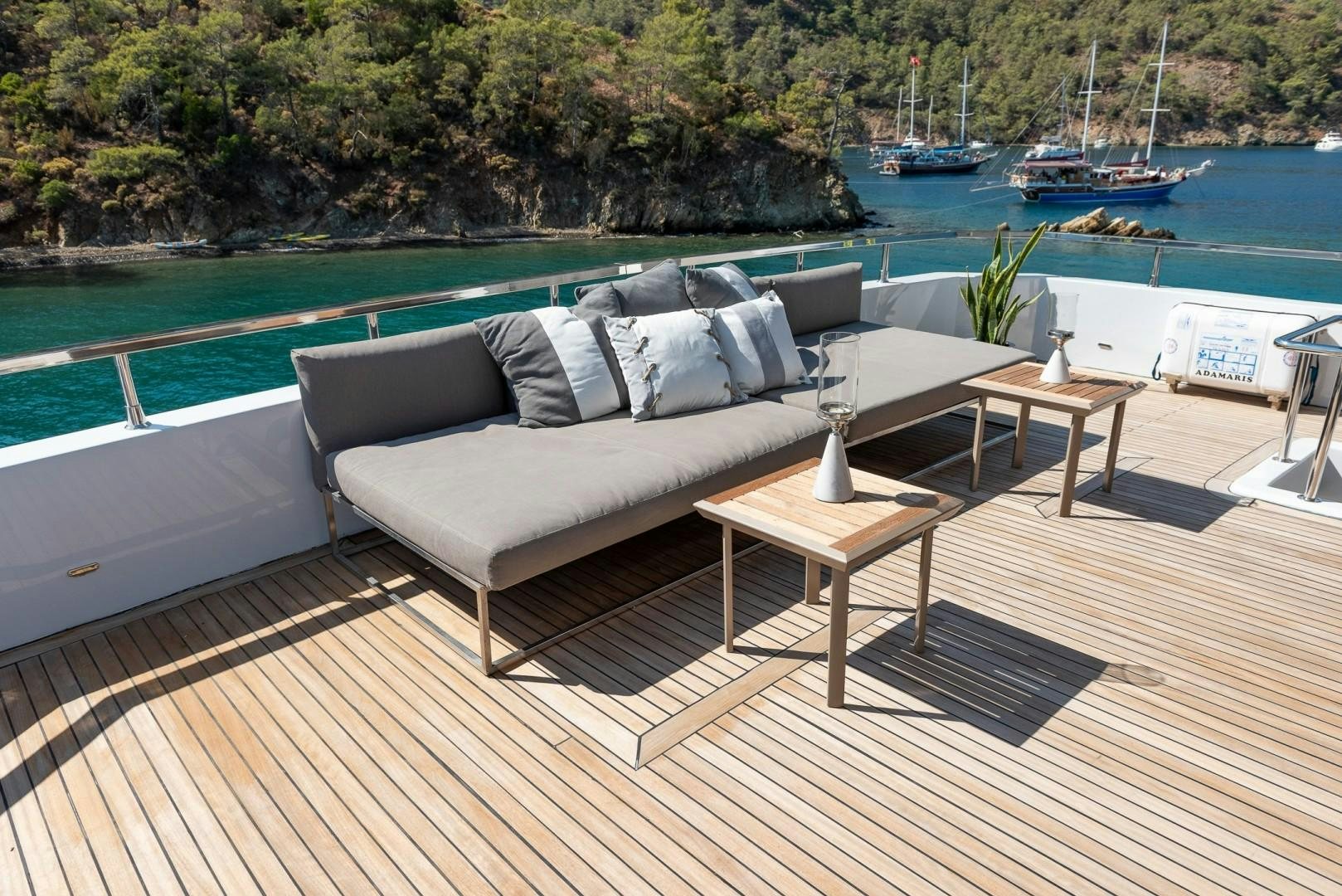 a couch on a deck overlooking a body of water aboard OCEAN BREEZE Yacht for Sale