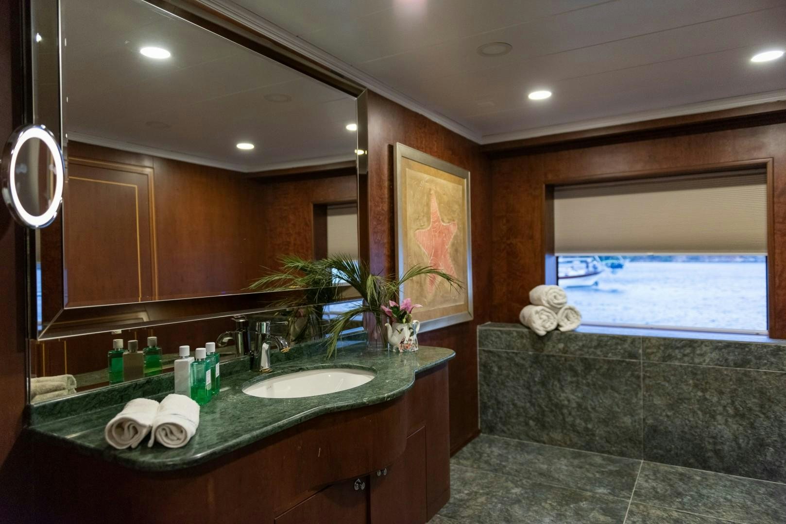 a bathroom with a countertop sink and a large mirror aboard OCEAN BREEZE Yacht for Sale