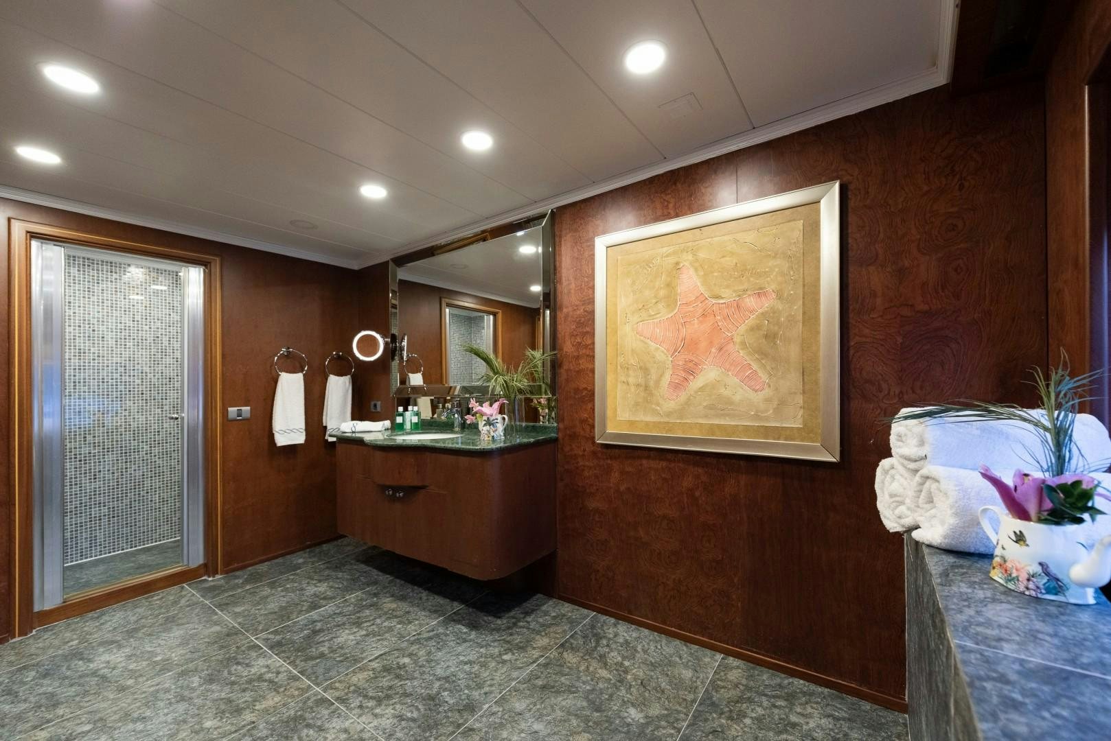 a bathroom with a painting on the wall aboard OCEAN BREEZE Yacht for Sale