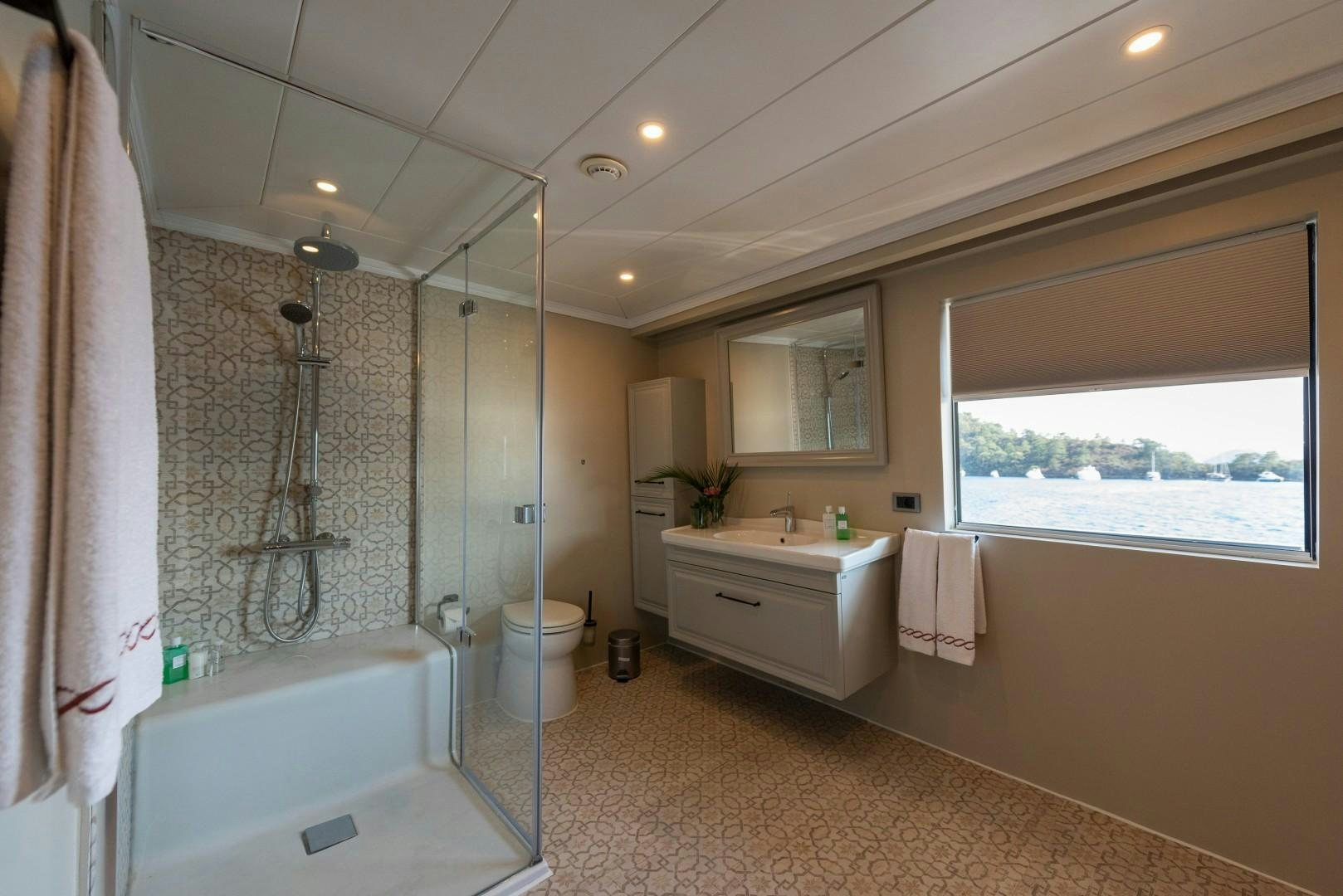 a bathroom with a tub sink and toilet aboard OCEAN BREEZE Yacht for Sale